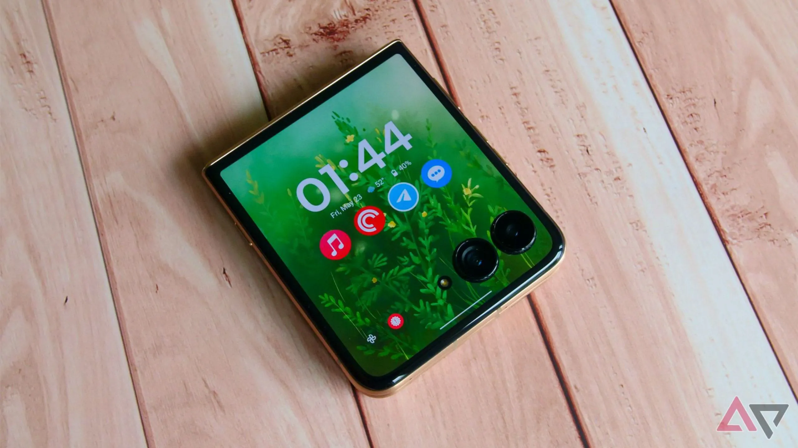 Điện thoại gập Motorola Razr Ultra 2025 màu xanh đặt trên bàn gỗ