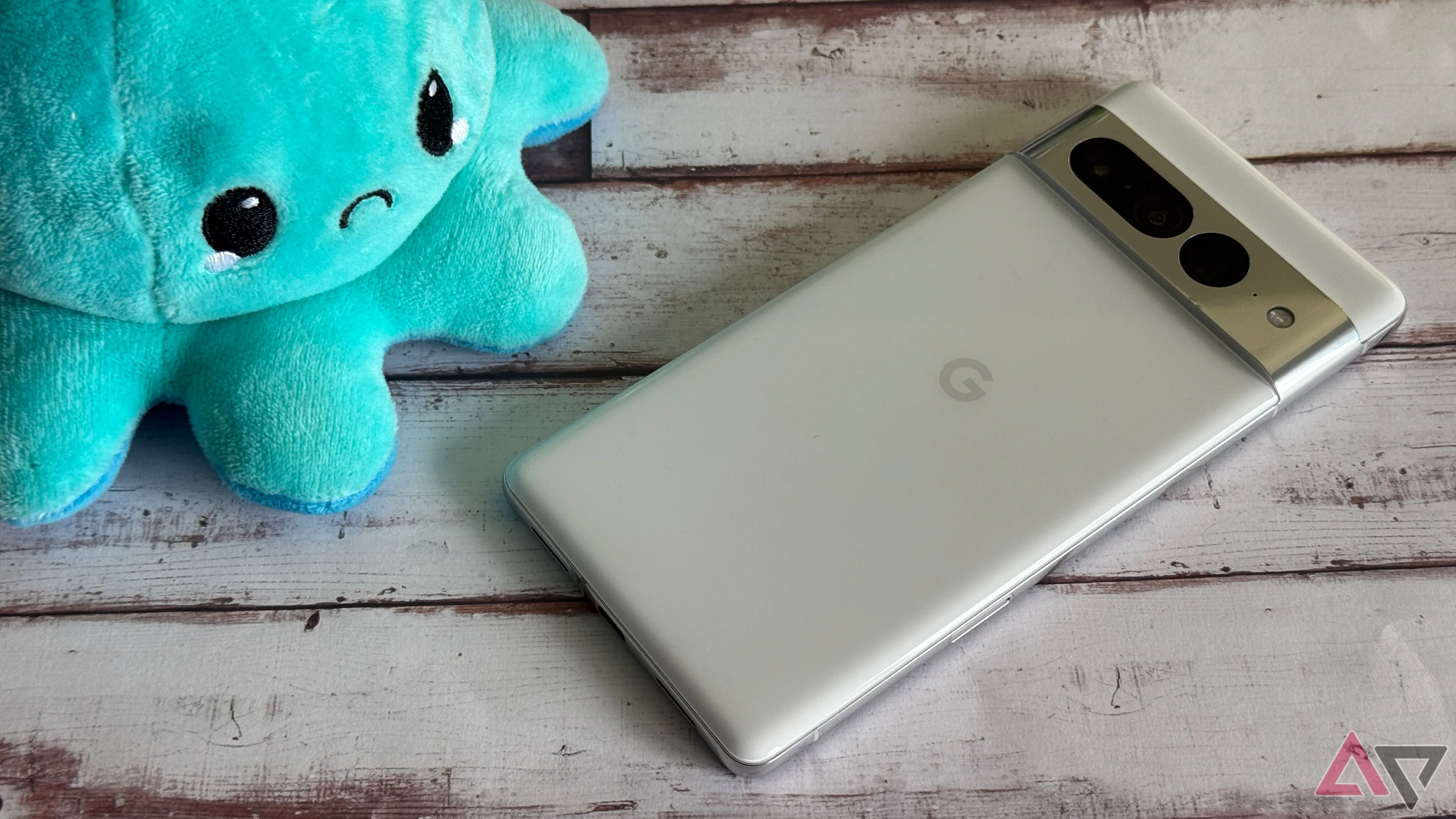 Điện thoại Google Pixel 7 Pro màu đen đặt cạnh biểu tượng cảm xúc mặt buồn màu xanh, thể hiện sự thất vọng về trải nghiệm hiệu năng và pin của chiếc flagship này.