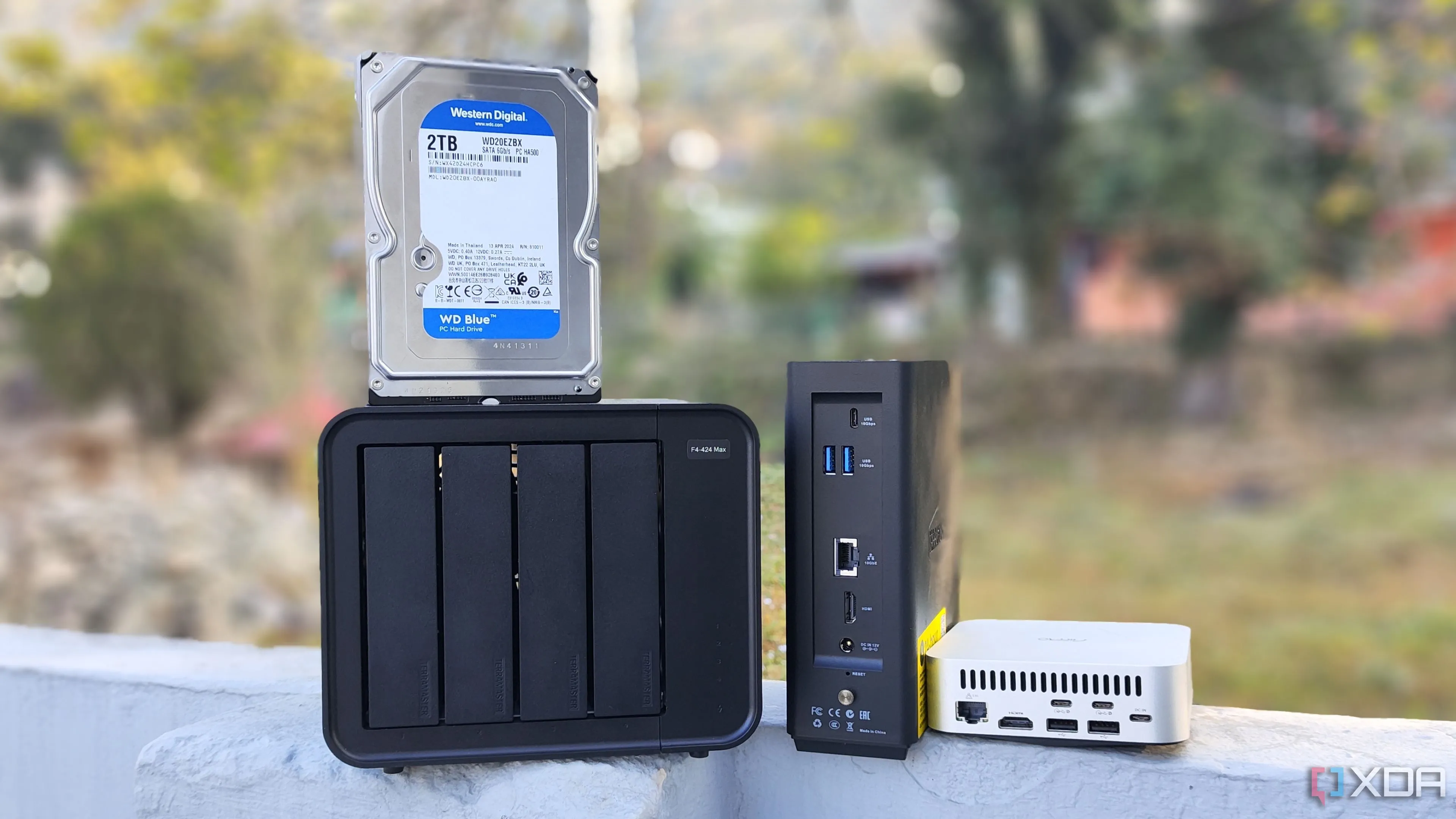 Ba thiết bị NAS (TerraMaster F4-424 Max, F8 SSD Plus, Aiffro K100) được đặt cạnh nhau, minh họa cho phần cứng có thể dùng để tự host trình quản lý mật khẩu.