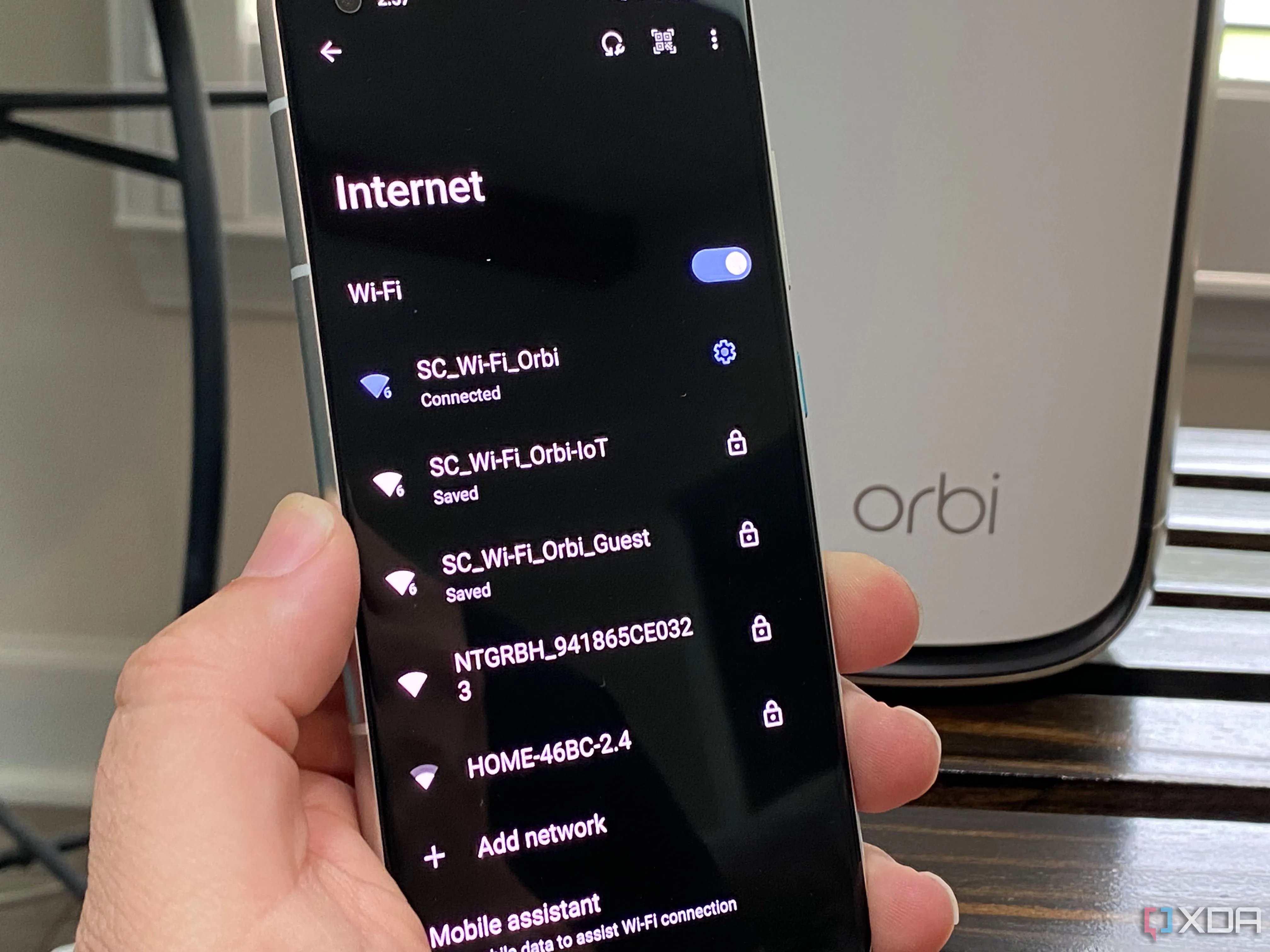 Hình ảnh bộ định tuyến Netgear với các tùy chọn mạng IoT và khách trên điện thoại Android, minh họa việc quản lý và tối ưu kết nối mạng.