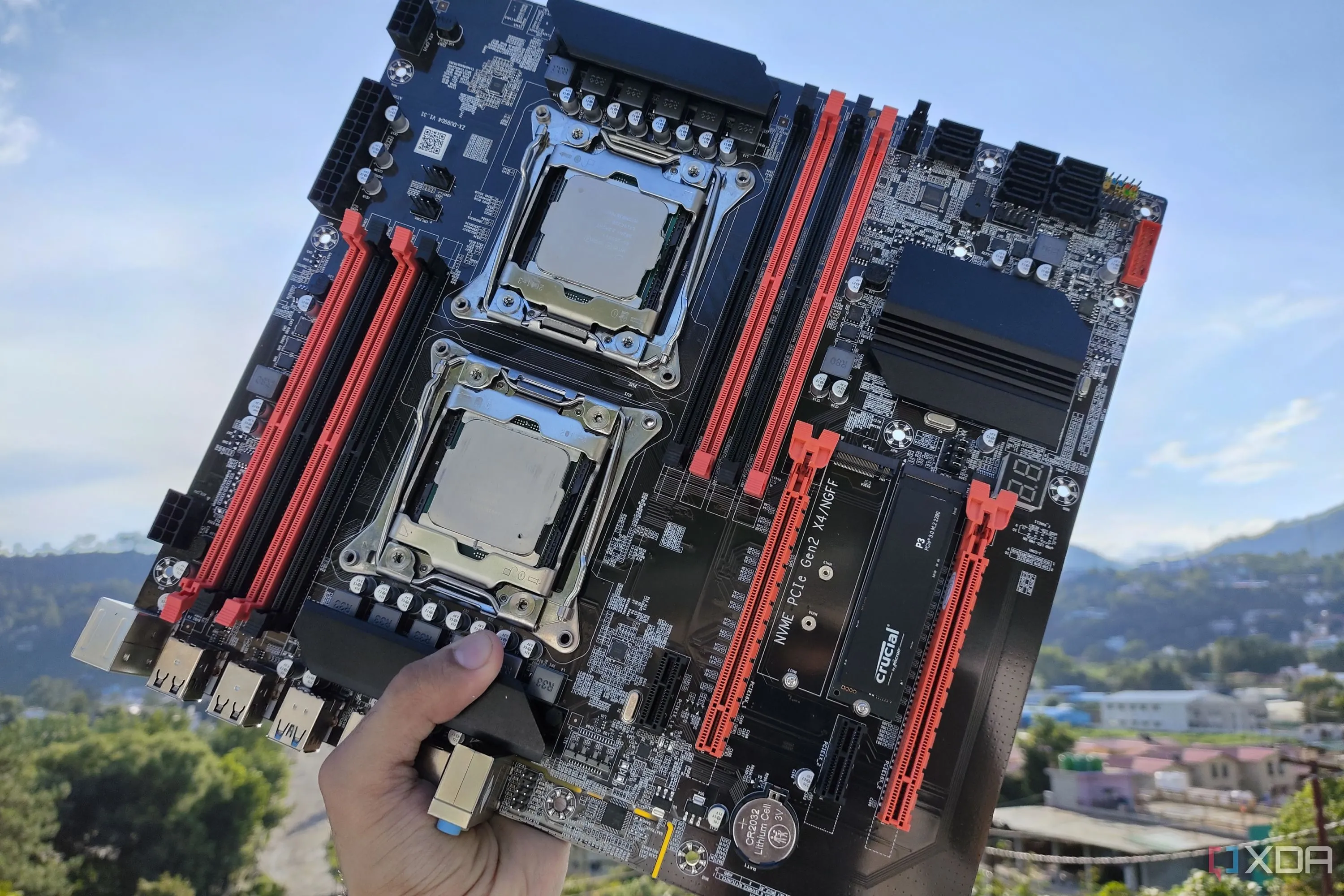 Một người đang cầm bo mạch chủ server X99 với hai CPU Intel Xeon được gắn, cho thấy vị trí các thành phần cần tản nhiệt.