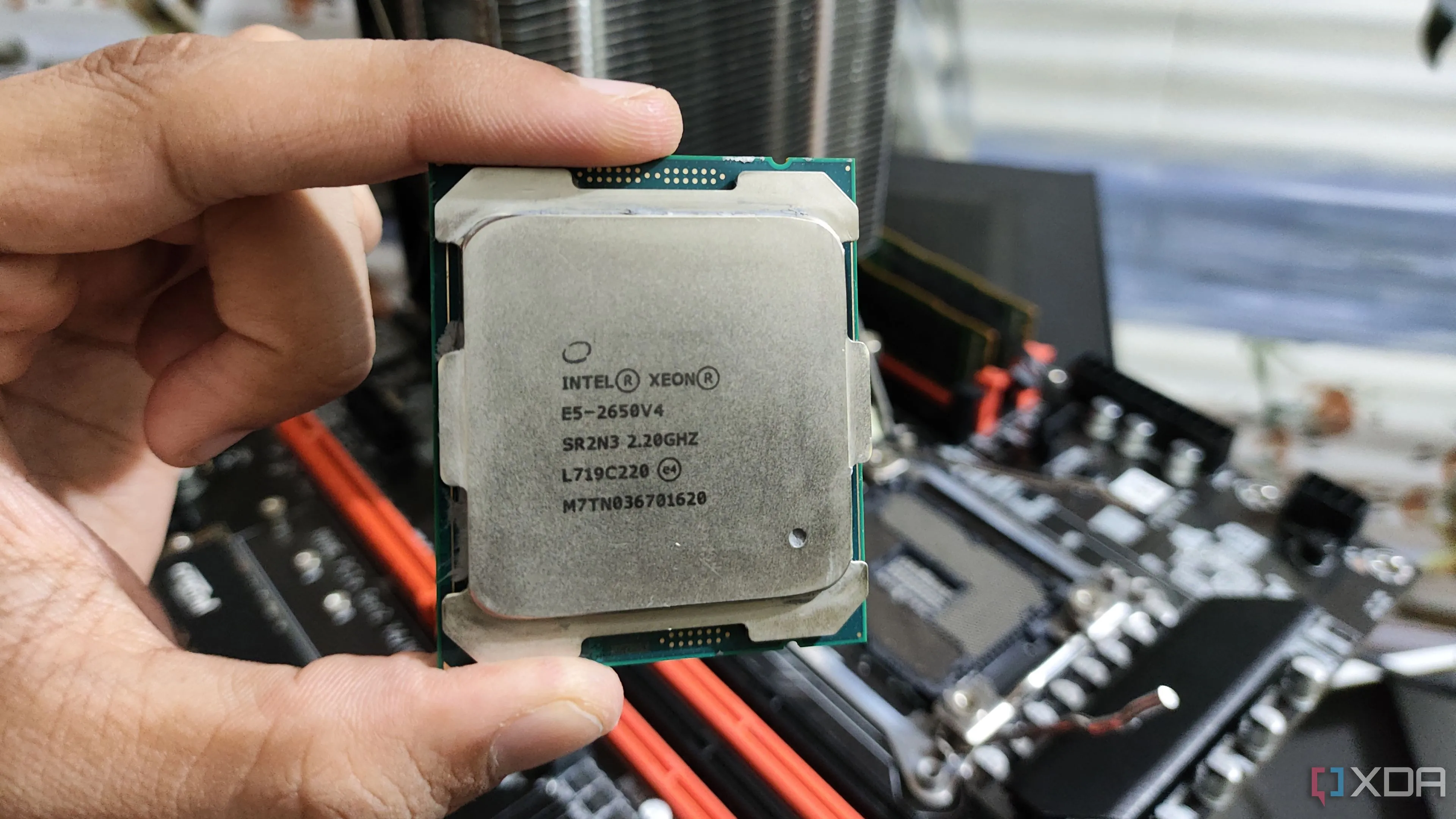 Một người đang cầm bộ vi xử lý Intel Xeon E5-2650 v4 cấp máy chủ, minh họa loại CPU thường dùng cho các bo mạch chủ server cũ.