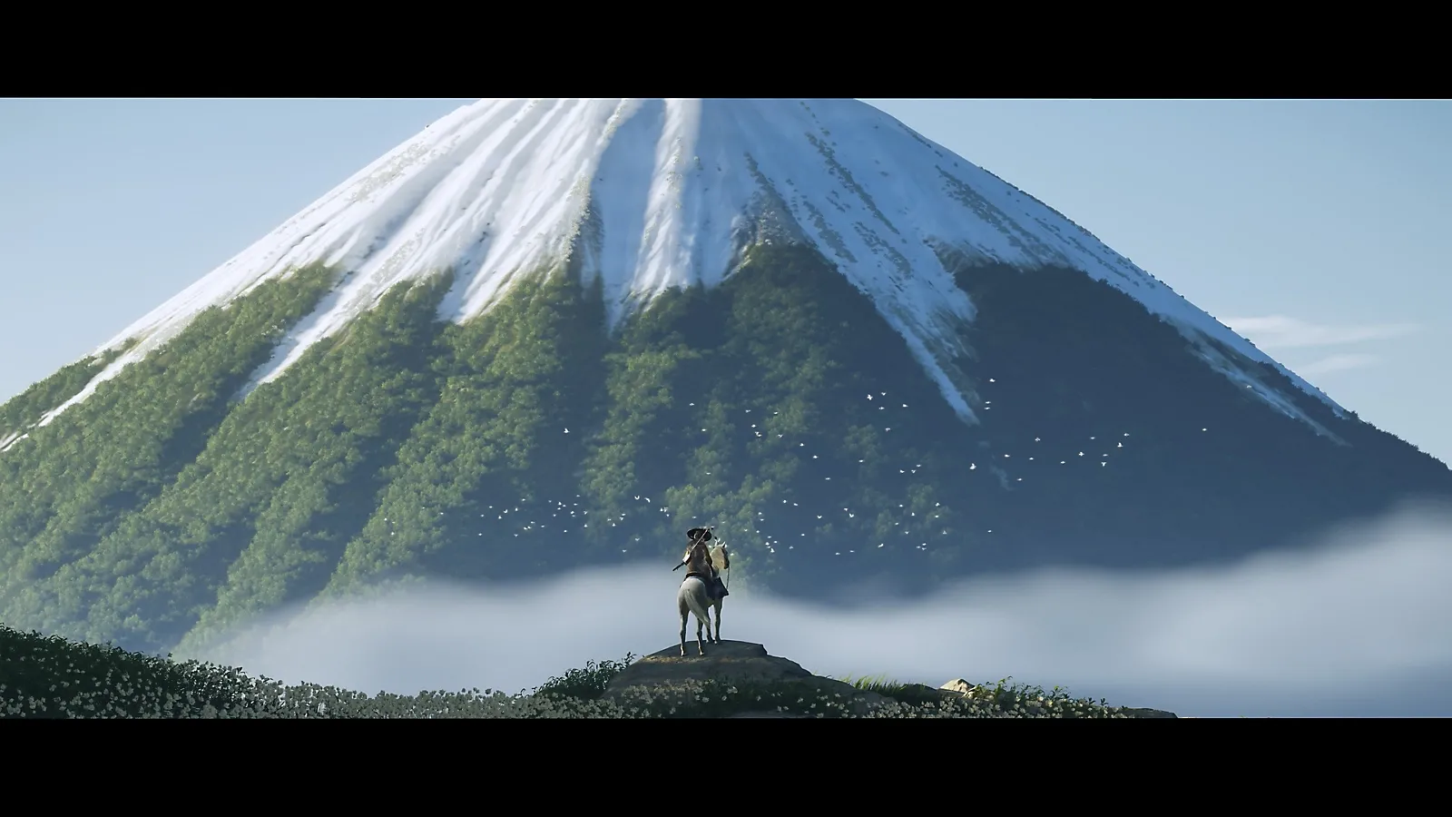 Atsu, nhân vật chính của Ghost of Yotei, đứng trên vách đá nhìn ra núi Yotei hùng vĩ, trong khung cảnh thiên nhiên tuyệt đẹp của Bắc Nhật Bản