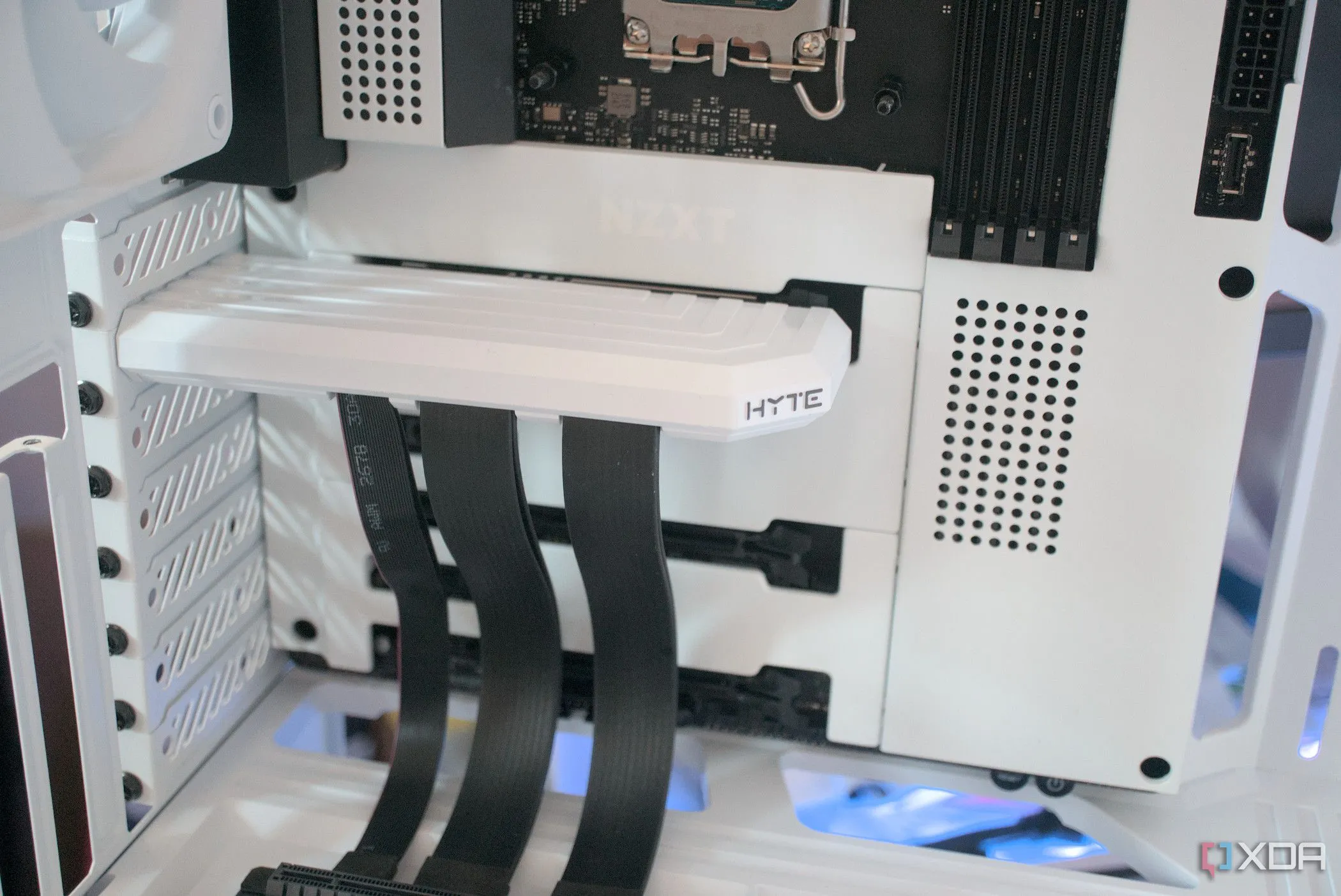 Bên trong case HYTE Y40 Snow White Edition với riser PCIe đã lắp, cho thấy cách bố trí linh kiện có thể ảnh hưởng đến thẩm mỹ tổng thể.