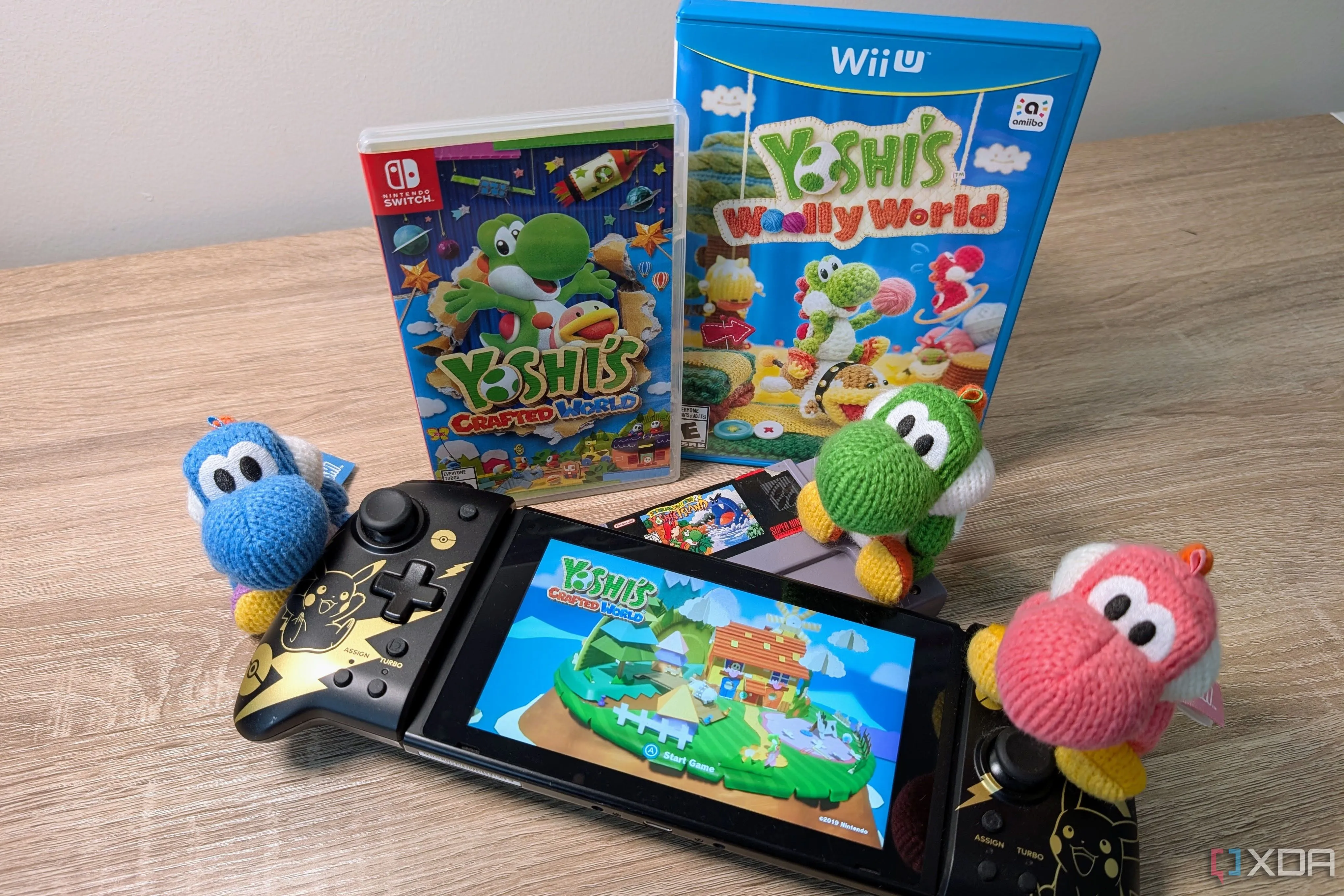 Bộ ba tượng Yoshi nhiều màu sắc bên cạnh máy Nintendo Switch chơi game Yoshi's Crafted World