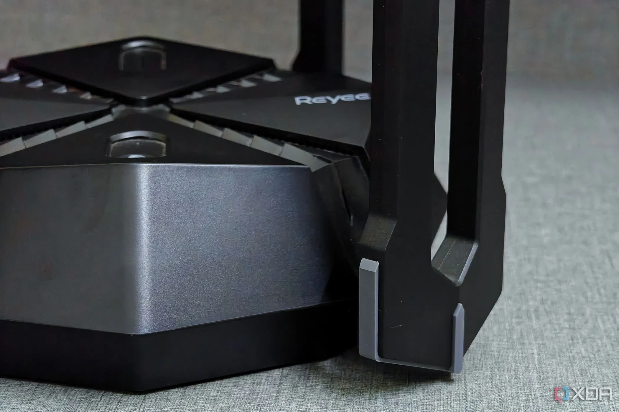 Bộ định tuyến gaming Reyee E6 với thiết kế góc cạnh đặt trên bàn, tượng trưng cho khả năng quản lý mạng hiệu quả và giảm nhiễu sóng.