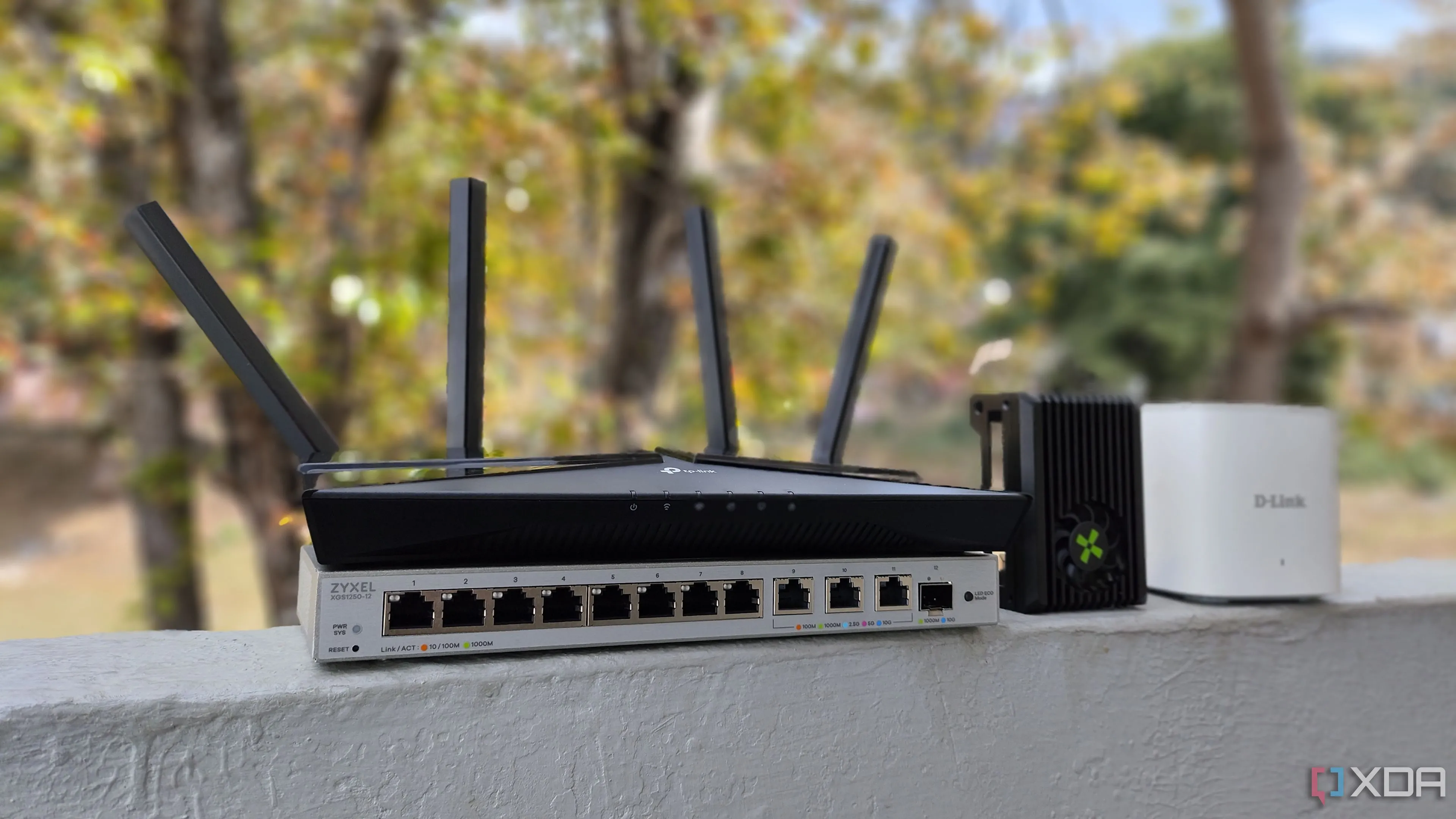 Bộ định tuyến TP-Link, máy tính bo mạch đơn Radxa X4, bộ định tuyến D-Link mesh và switch mạng Zyxel, minh họa hệ thống mạng gia đình