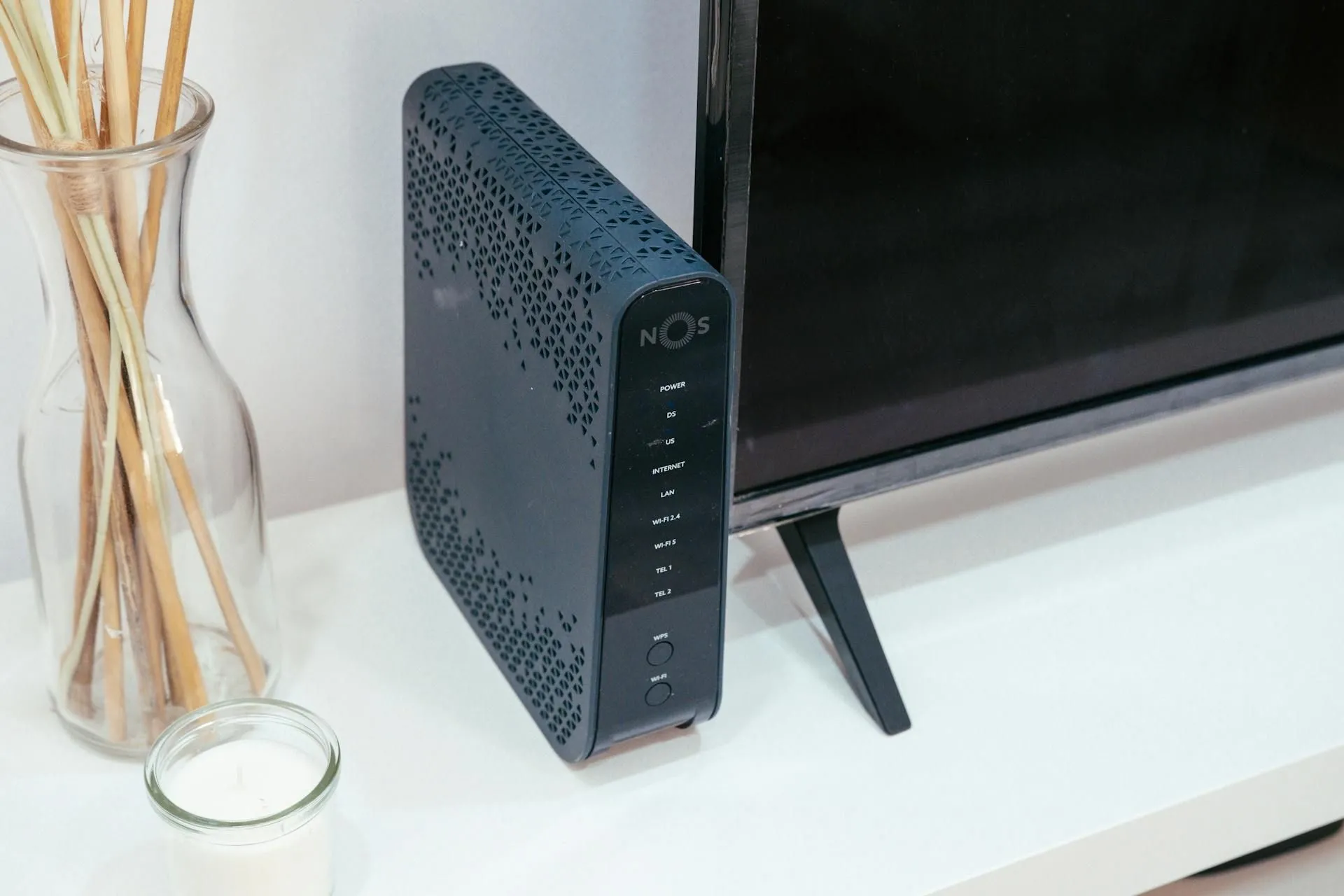 Bộ định tuyến Wi-Fi gia đình đặt cạnh tivi và vật trang trí, thể hiện không gian sống hiện đại