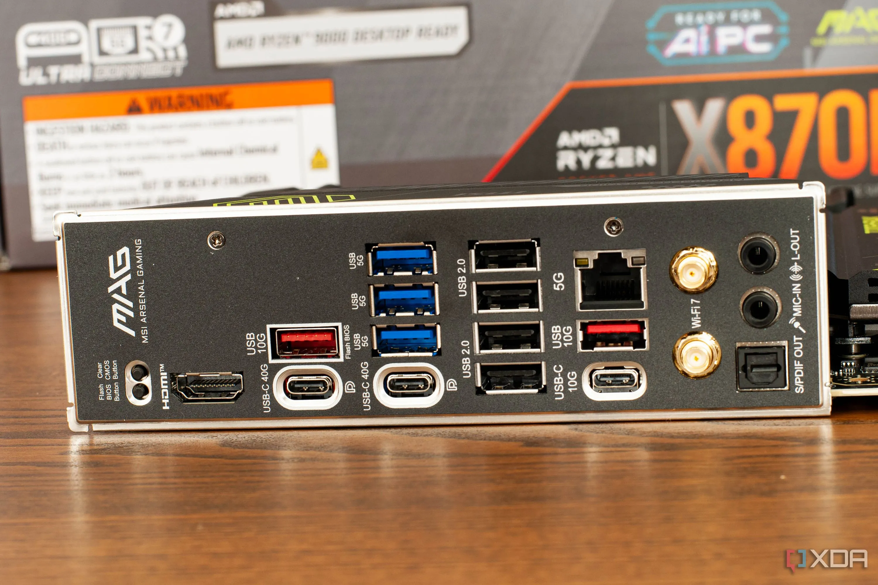 Bo mạch chủ MSI đặt trên bàn làm việc, cận cảnh khu vực cổng I/O phía sau và các khe cắm RAM, cho thấy sự đa dạng của các cổng kết nối hiện nay.