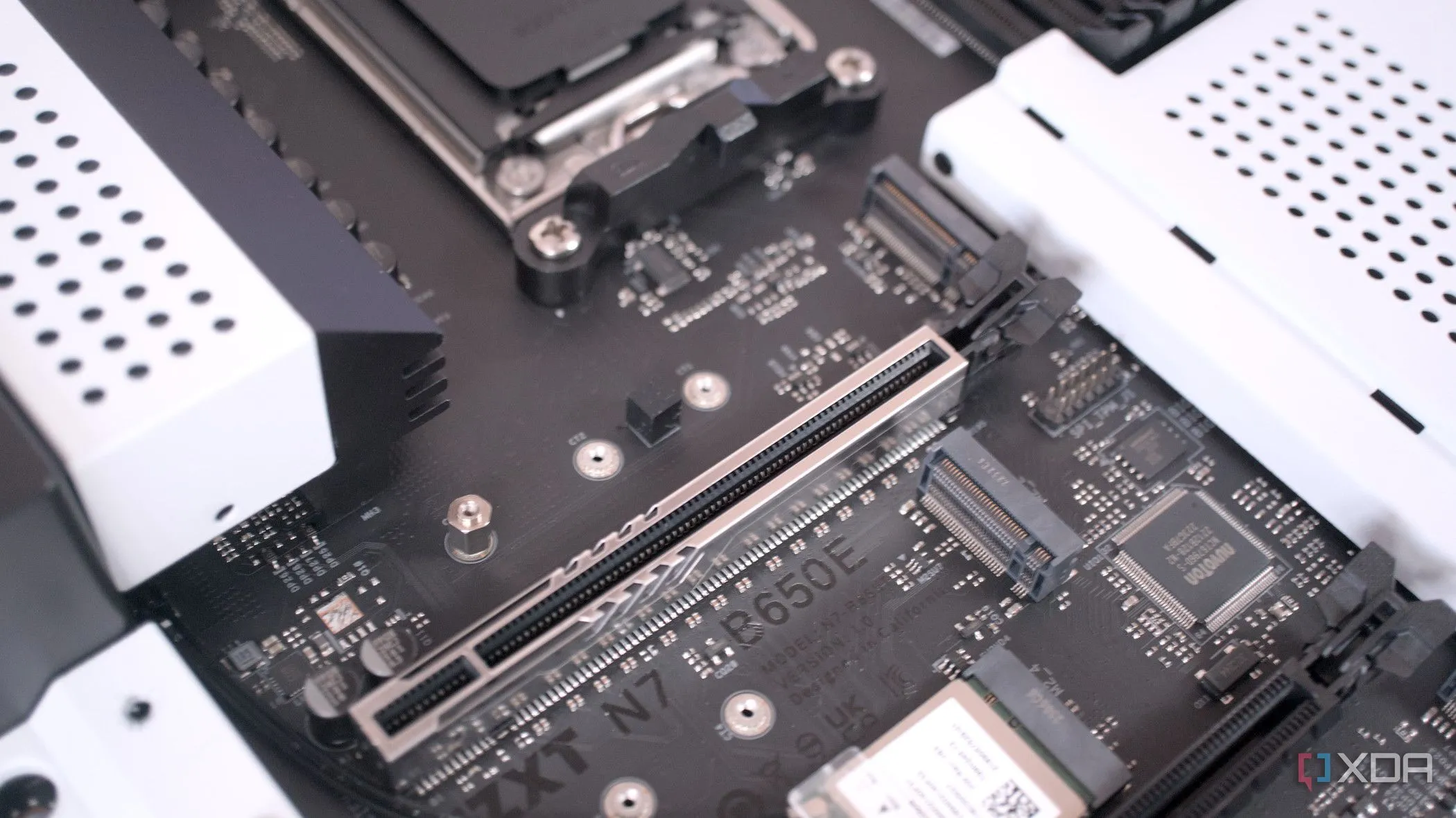 Các khe cắm mở rộng trên bo mạch chủ NZXT N7 B650E với nắp SSD đã tháo