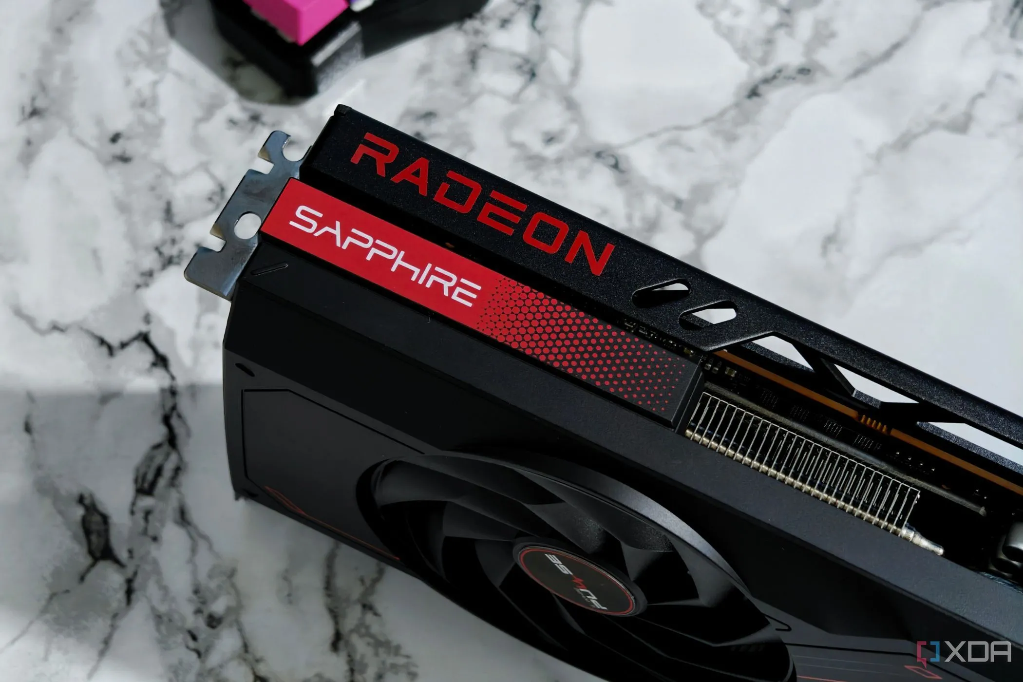 Card đồ họa AMD Radeon RX 7700 XT đặt trên bàn, tượng trưng cho sản phẩm GPU của AMD trong bối cảnh so sánh phần mềm.