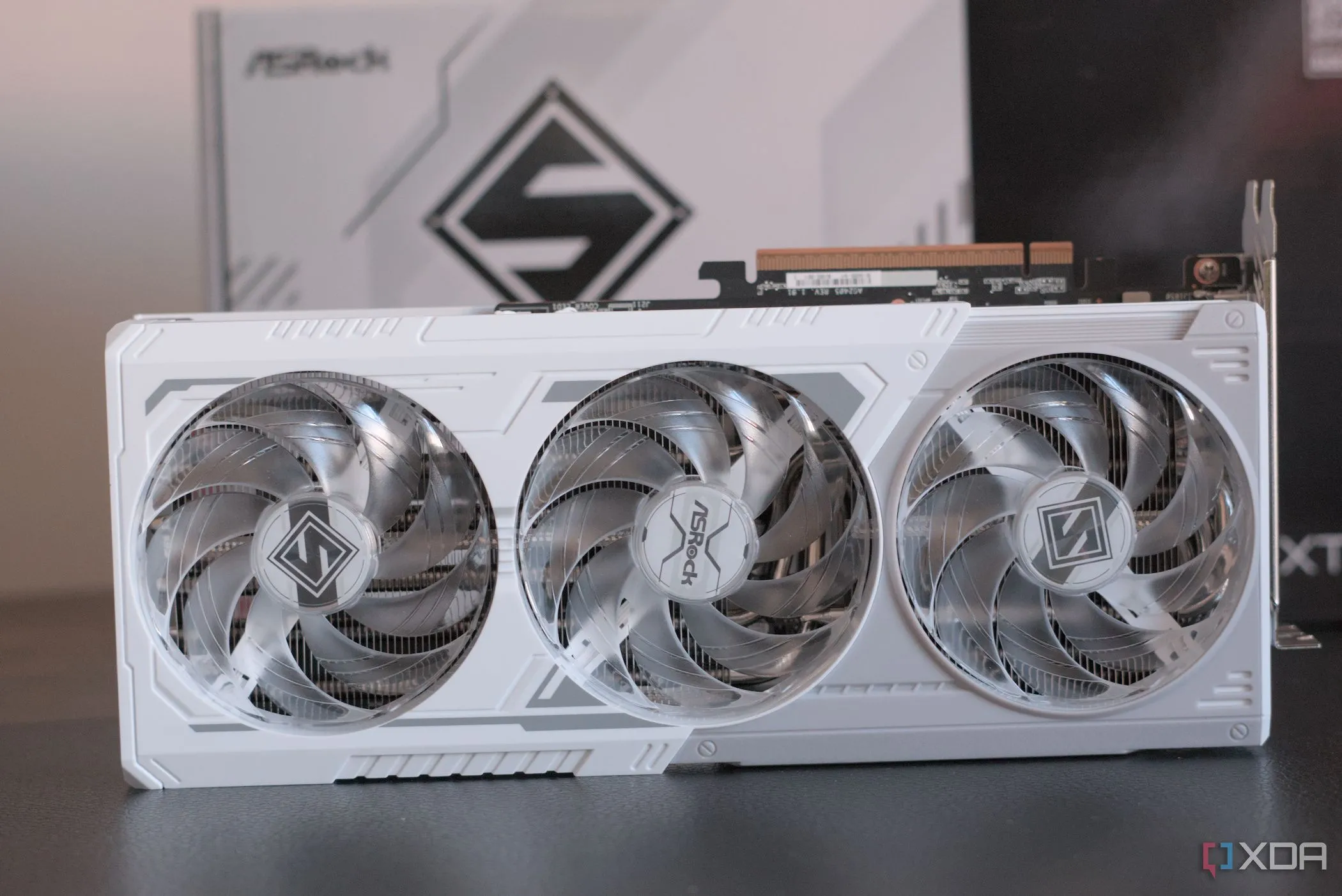 Card đồ họa ASRock Radeon RX 9070 XT Steel Legend đặt trước hộp sản phẩm, làm nổi bật thiết kế và thương hiệu