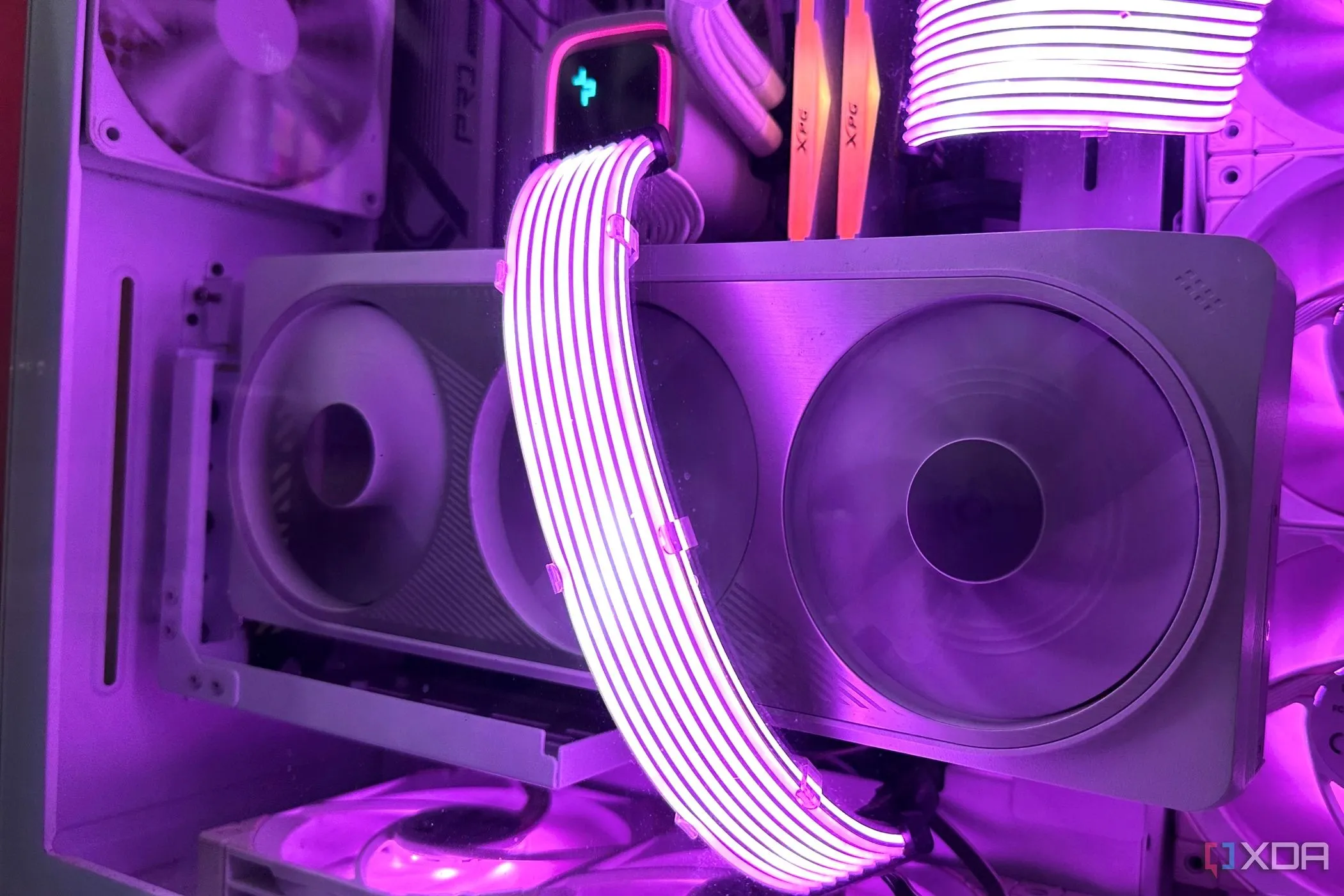 Card đồ họa NVIDIA RTX 4070 Ti màu trắng đặt dọc trong vỏ case trắng, với cáp Lian Li Strimer màu tím, nhấn mạnh thiết kế thẩm mỹ của GPU hiện đại.