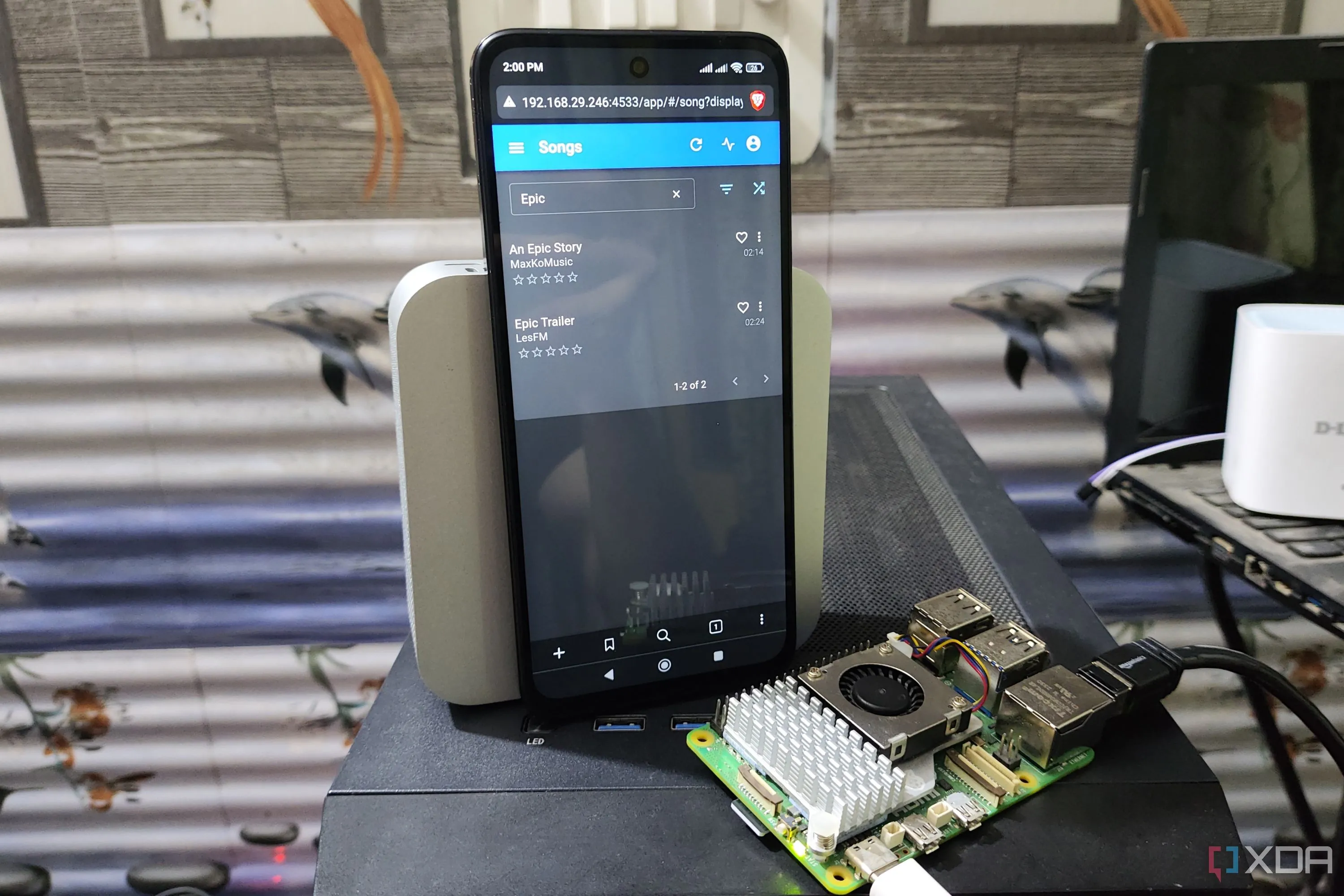 Giao diện web của Navidrome trên điện thoại Poco M6 Pro, bên cạnh là Raspberry Pi 5, thể hiện khả năng stream nhạc tự host mượt mà trên thiết bị cấu hình thấp.