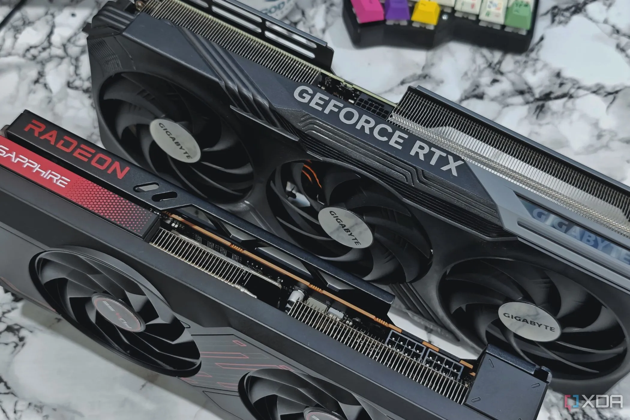Hai card đồ họa NVIDIA GeForce RTX 4070 Ti và AMD Radeon RX 7700XT trên bàn