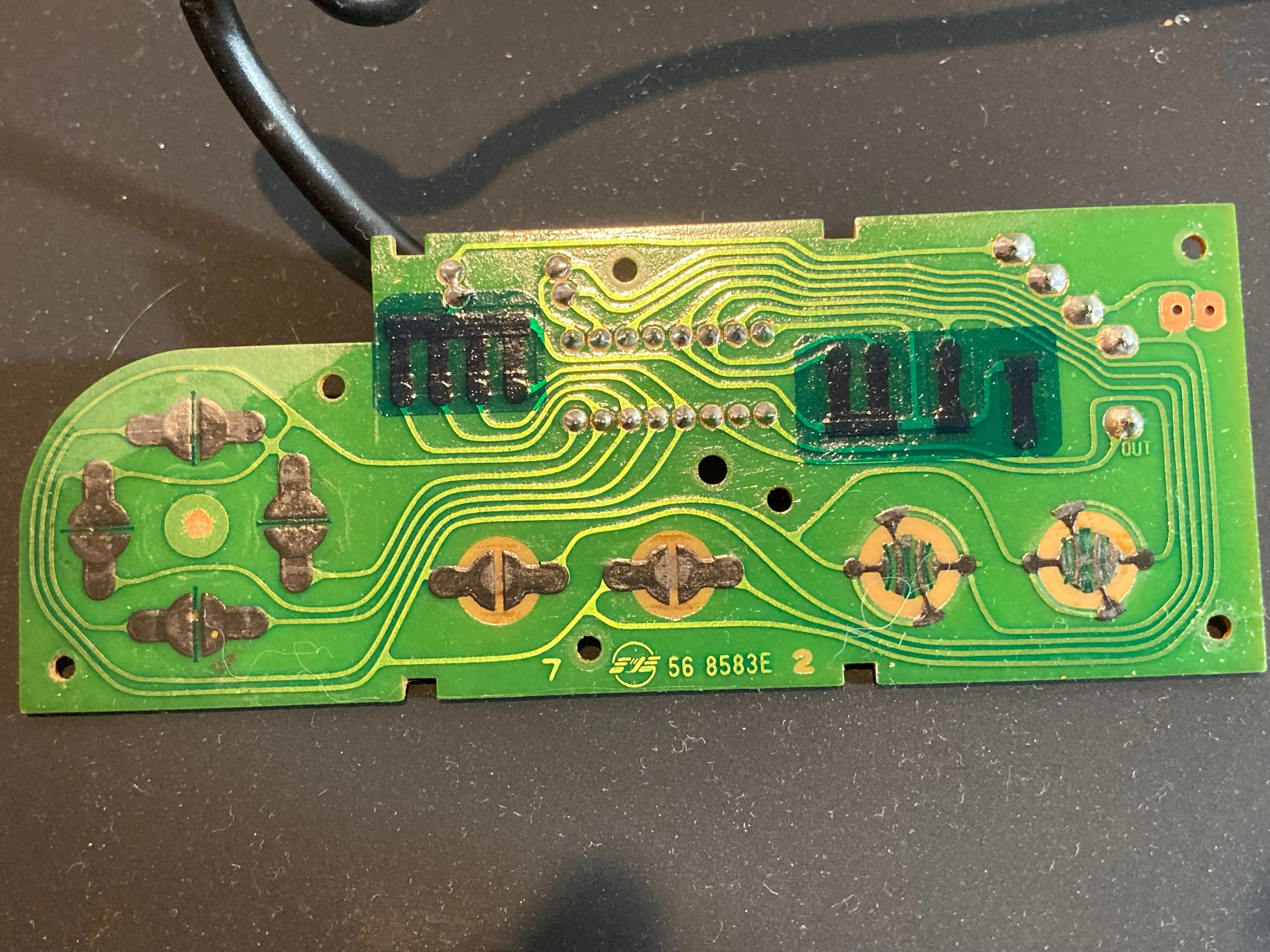Hình ảnh cận cảnh bo mạch PCB mặt trước bên trong tay cầm NES, hiển thị các điểm tiếp xúc nút bấm