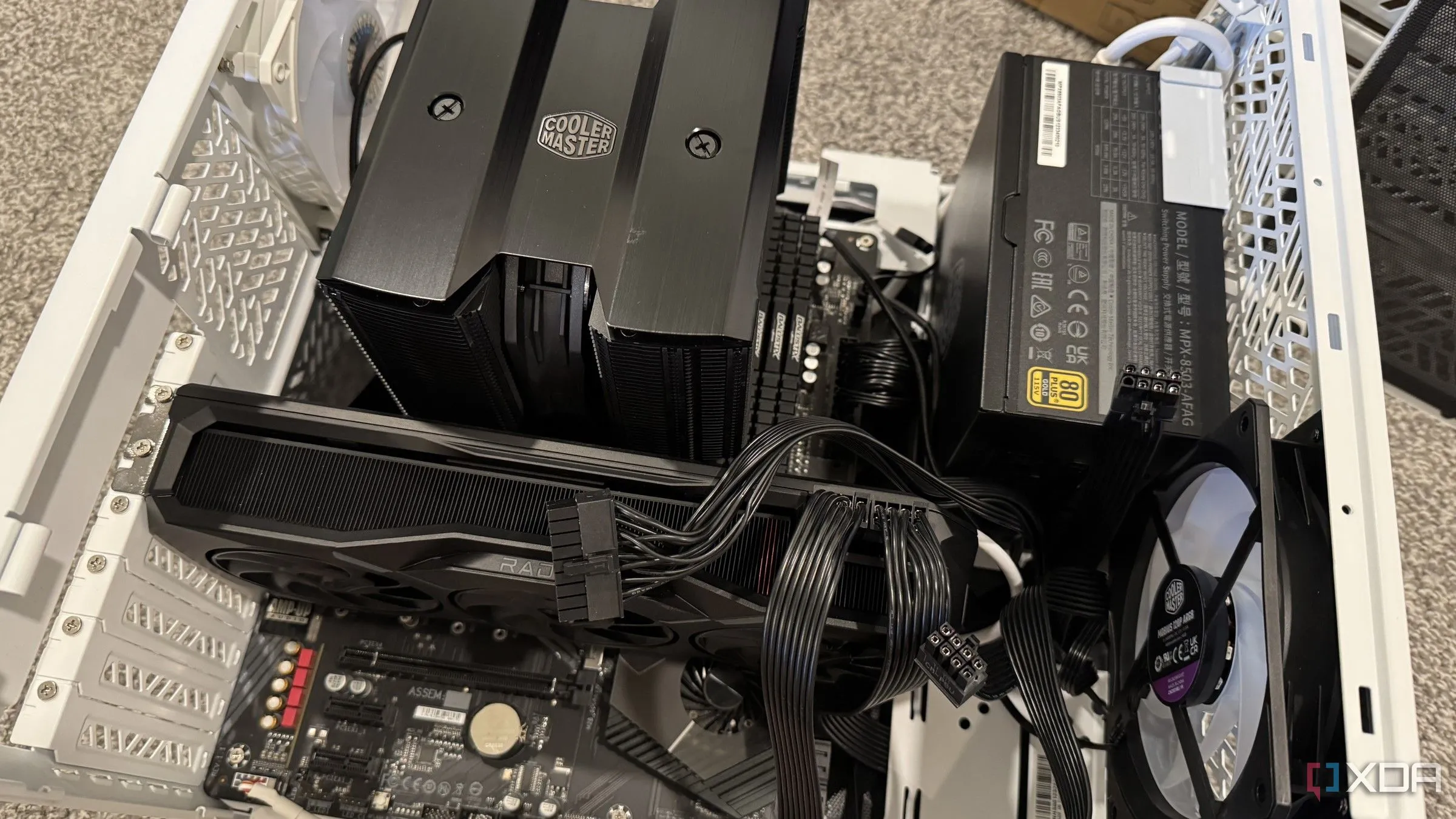 Hình ảnh một PC đang được lắp ráp với cáp GPU đã cắm, làm nổi bật không gian hạn chế và thách thức tản nhiệt bên trong thùng máy tính nhỏ gọn