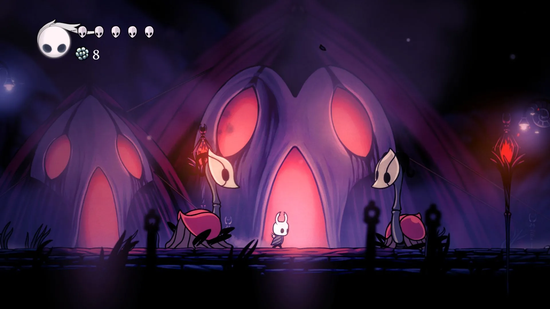 Hollow Knight, nhân vật chính từ tựa game phiêu lưu hành động nổi tiếng, đứng giữa hai quái vật trong một phân cảnh đồ họa tuyệt đẹp