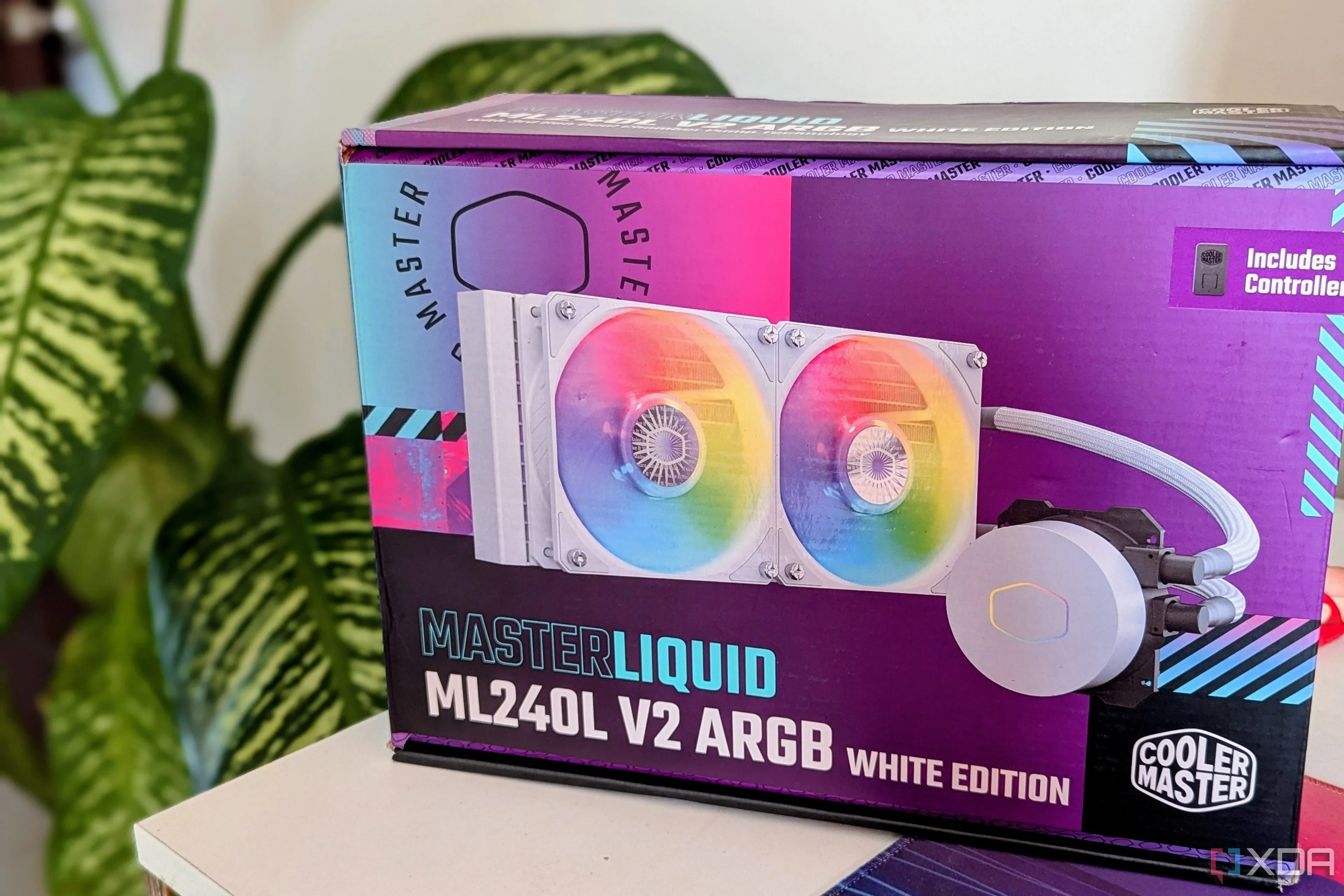 Hộp tản nhiệt nước AIO hiệu Cooler Master đặt trên bàn làm việc cạnh cây xanh, nhấn mạnh vai trò quan trọng của tản nhiệt cho CPU hiệu năng cao