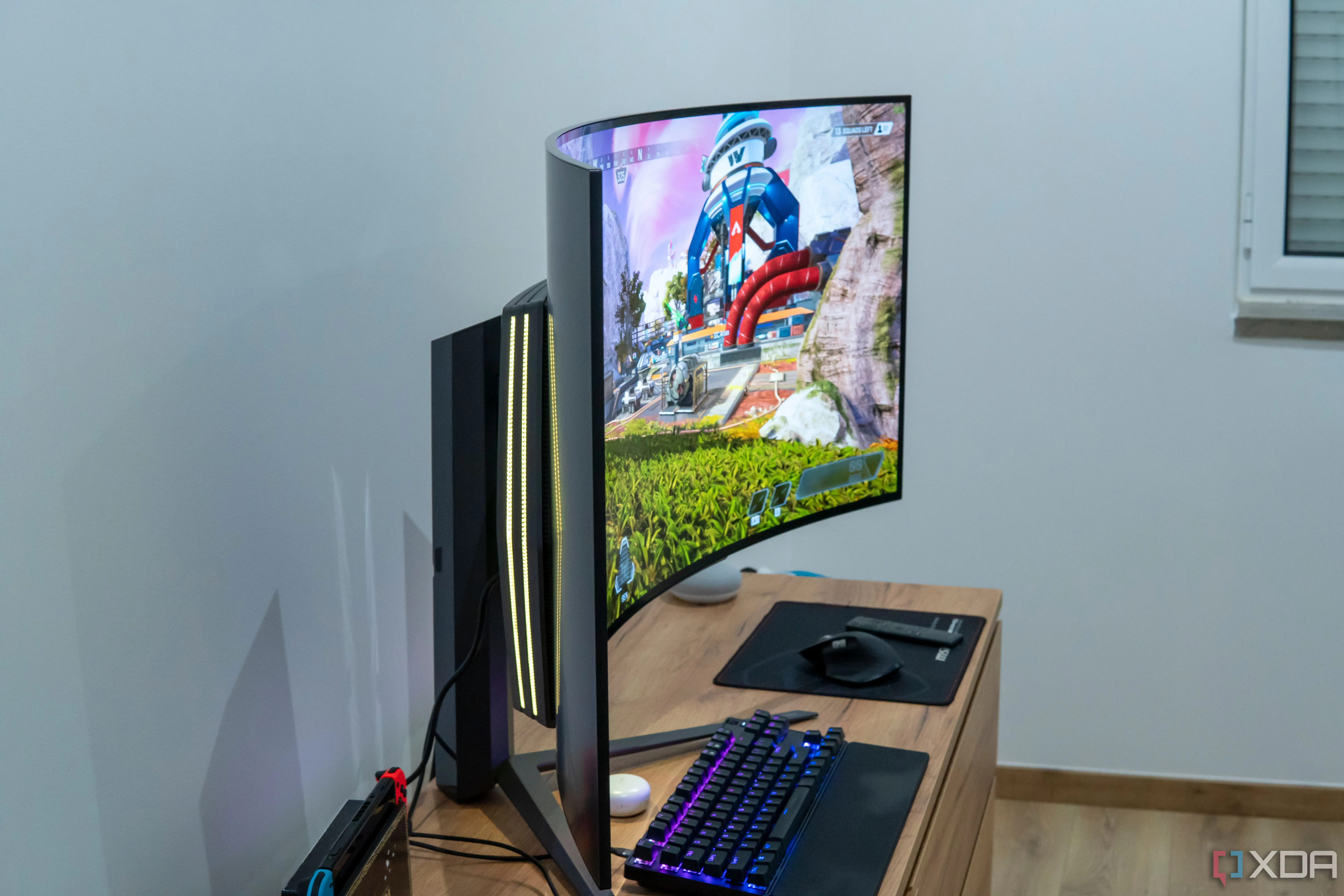 Màn hình LG UltraGear 45GR95QE nhìn từ bên cạnh, hiển thị ánh sáng RGB và đang chạy game Apex Legends