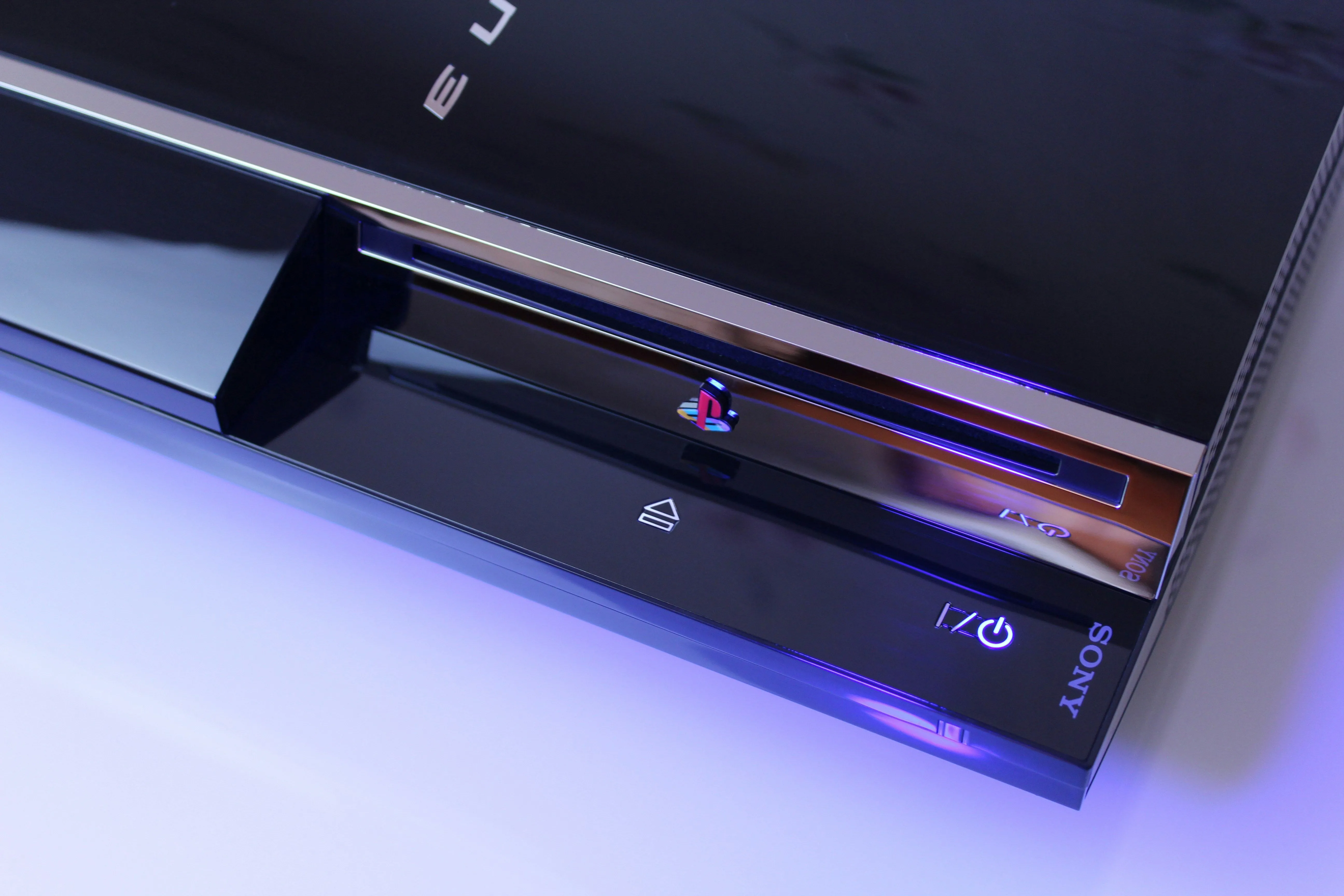 Máy chơi game PlayStation 3 thế hệ cũ với khay đĩa, nút nguồn và logo PlayStation