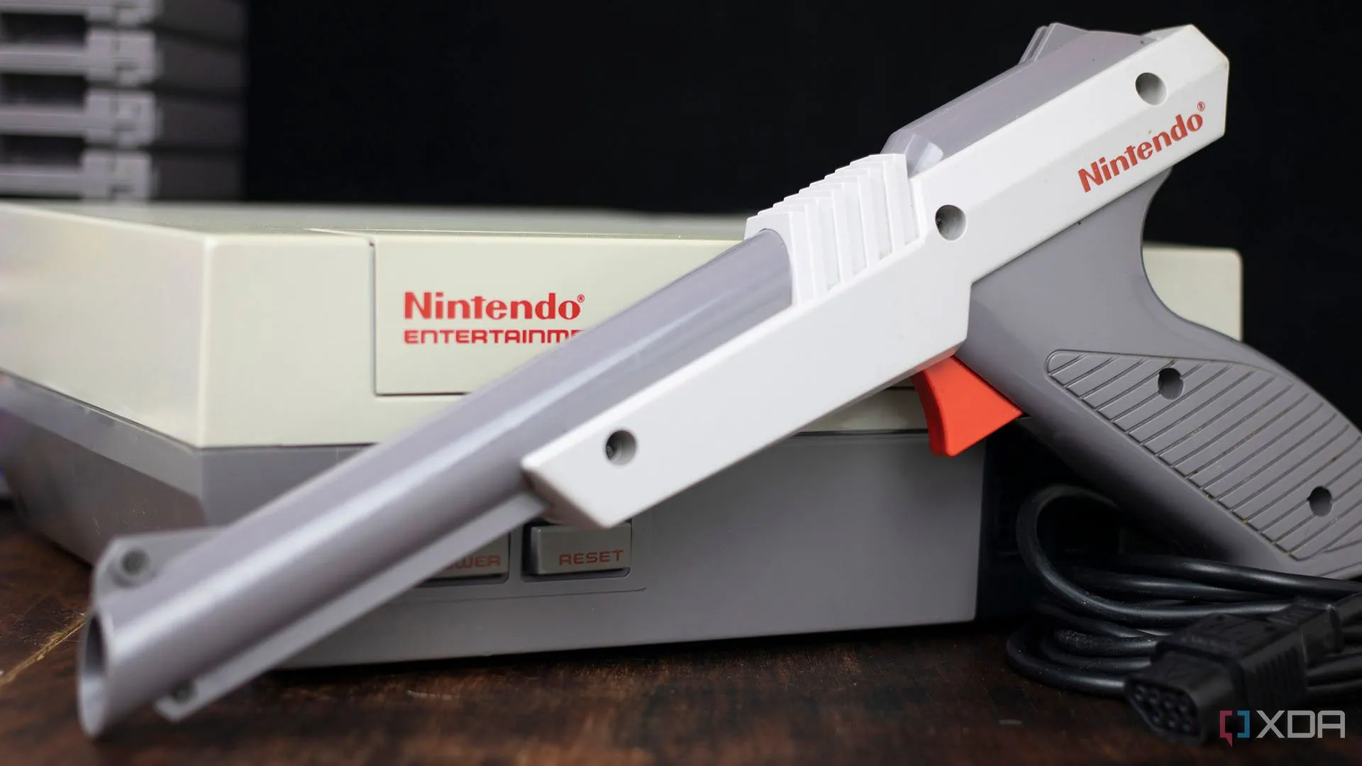Máy console NES cổ điển và súng Zapper đặt trên bề mặt tối