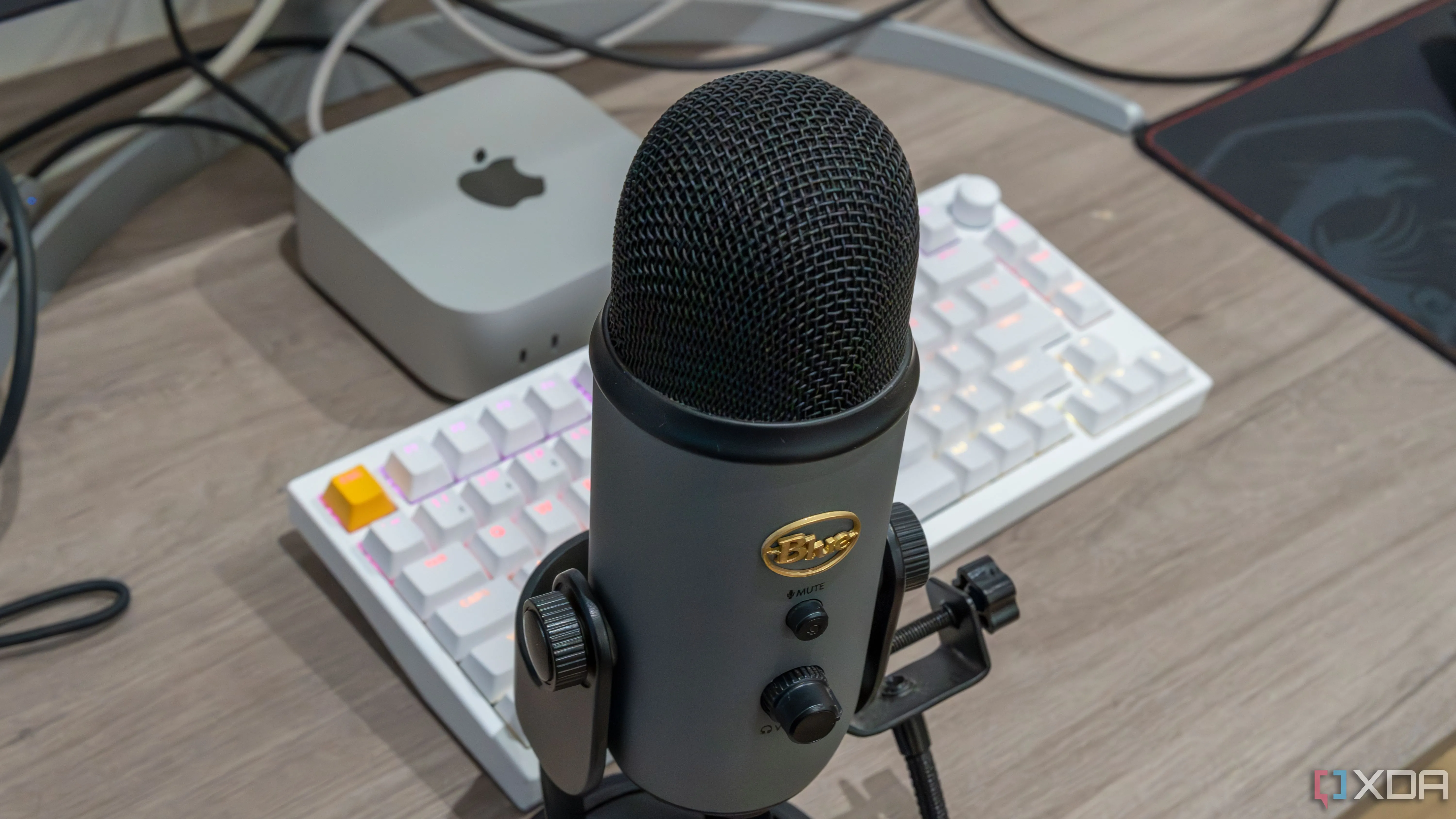 Microphone USB Blue Yeti đặt trước Mac Mini và bàn phím, gợi ý về trải nghiệm voice chat trong các game kinh dị nhiều người chơi