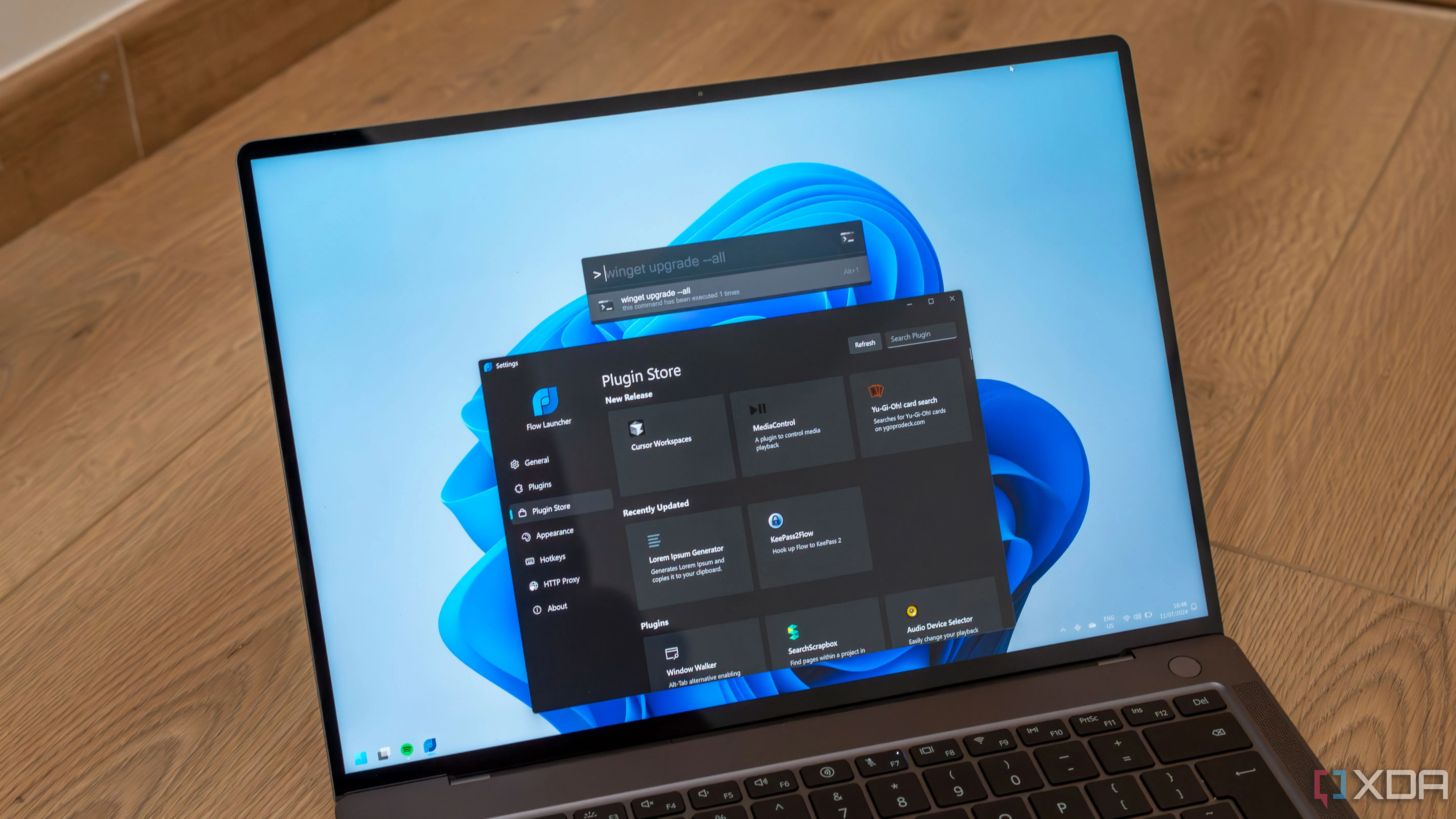 Một chiếc laptop Windows 11 hiển thị cài đặt Flow Launcher và thanh tìm kiếm, thể hiện giao diện tối ưu hóa và giám sát
