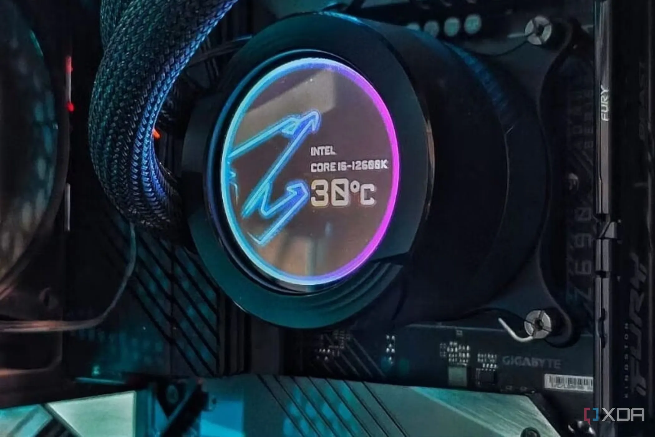 Một khối tản nhiệt nước (liquid cooler waterblock) hiển thị nhiệt độ CPU, được gắn trên bo mạch chủ.