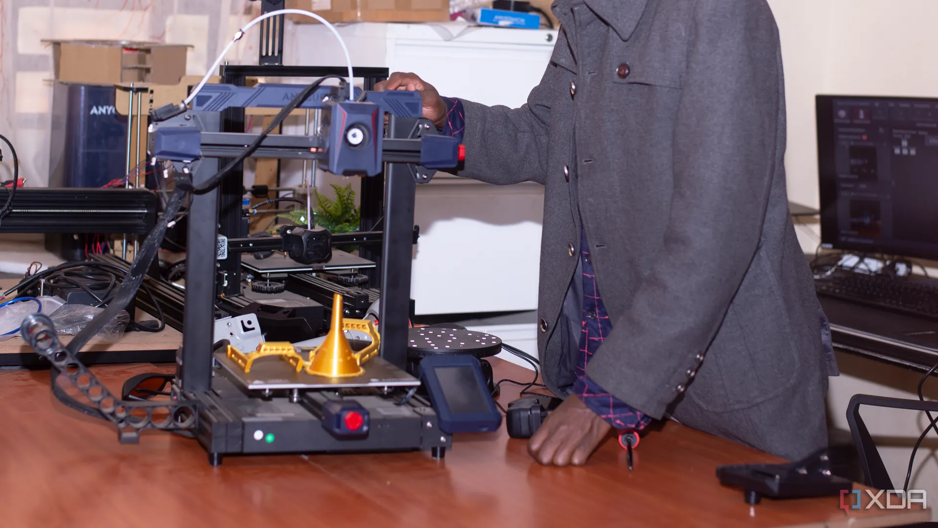 Một người đàn ông đang kiểm tra máy in 3D Anycubic trong quá trình in ấn
