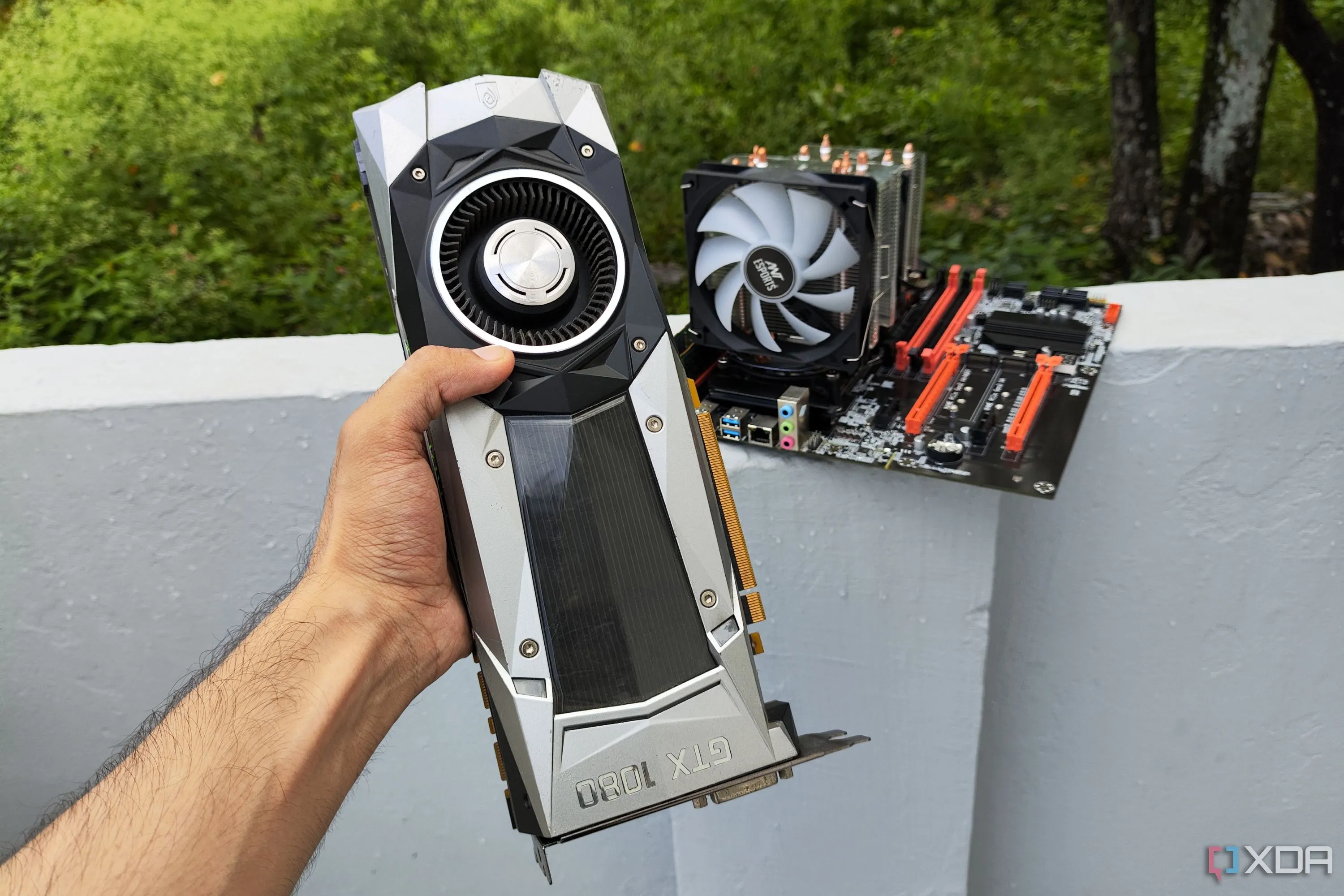 Một người đang cầm card đồ họa GTX 1080 Founders Edition trước một máy chủ PC