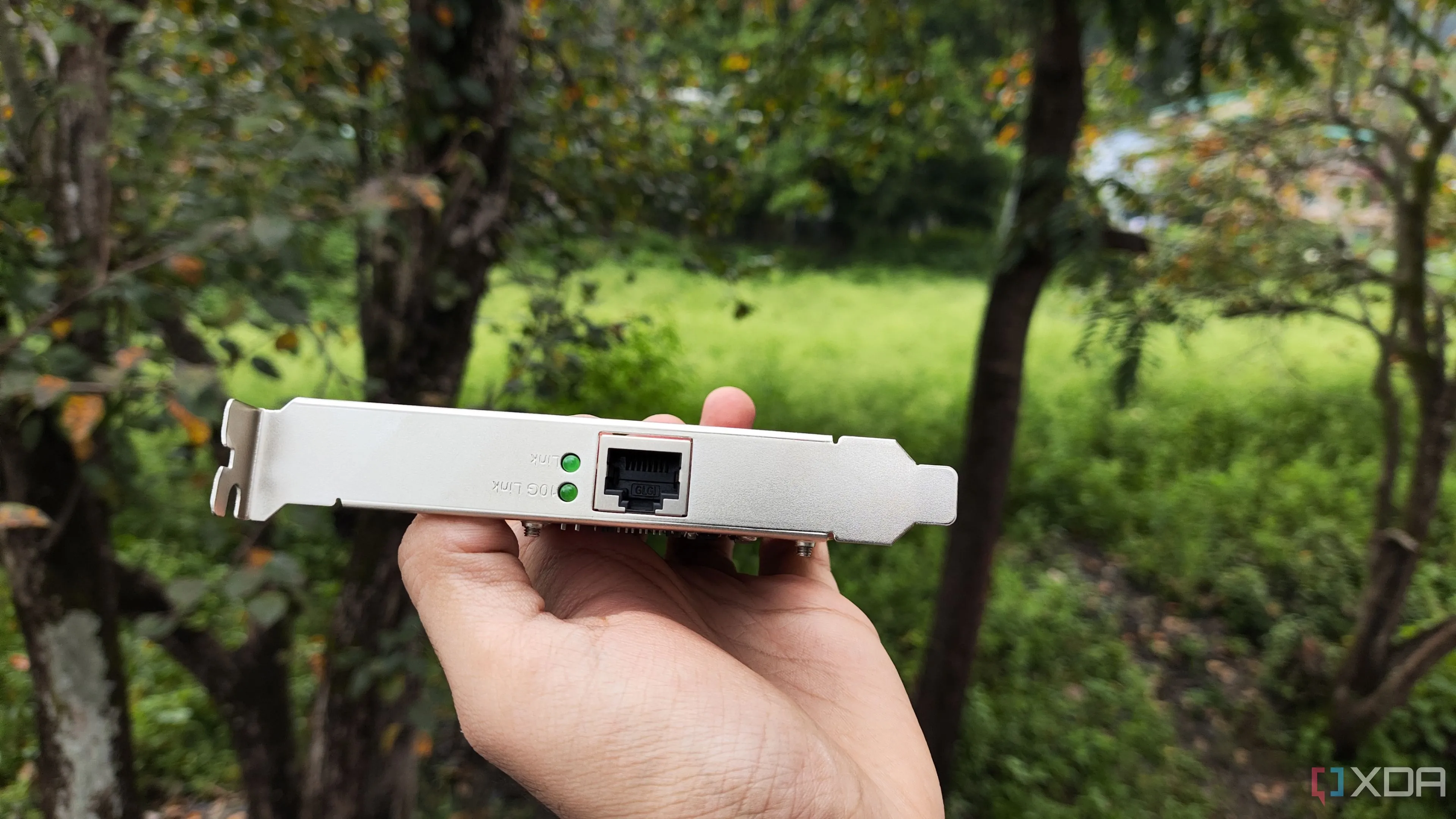 Một người đang cầm card mạng 10G của TP-Link, thể hiện sự nâng cấp tốc độ mạng
