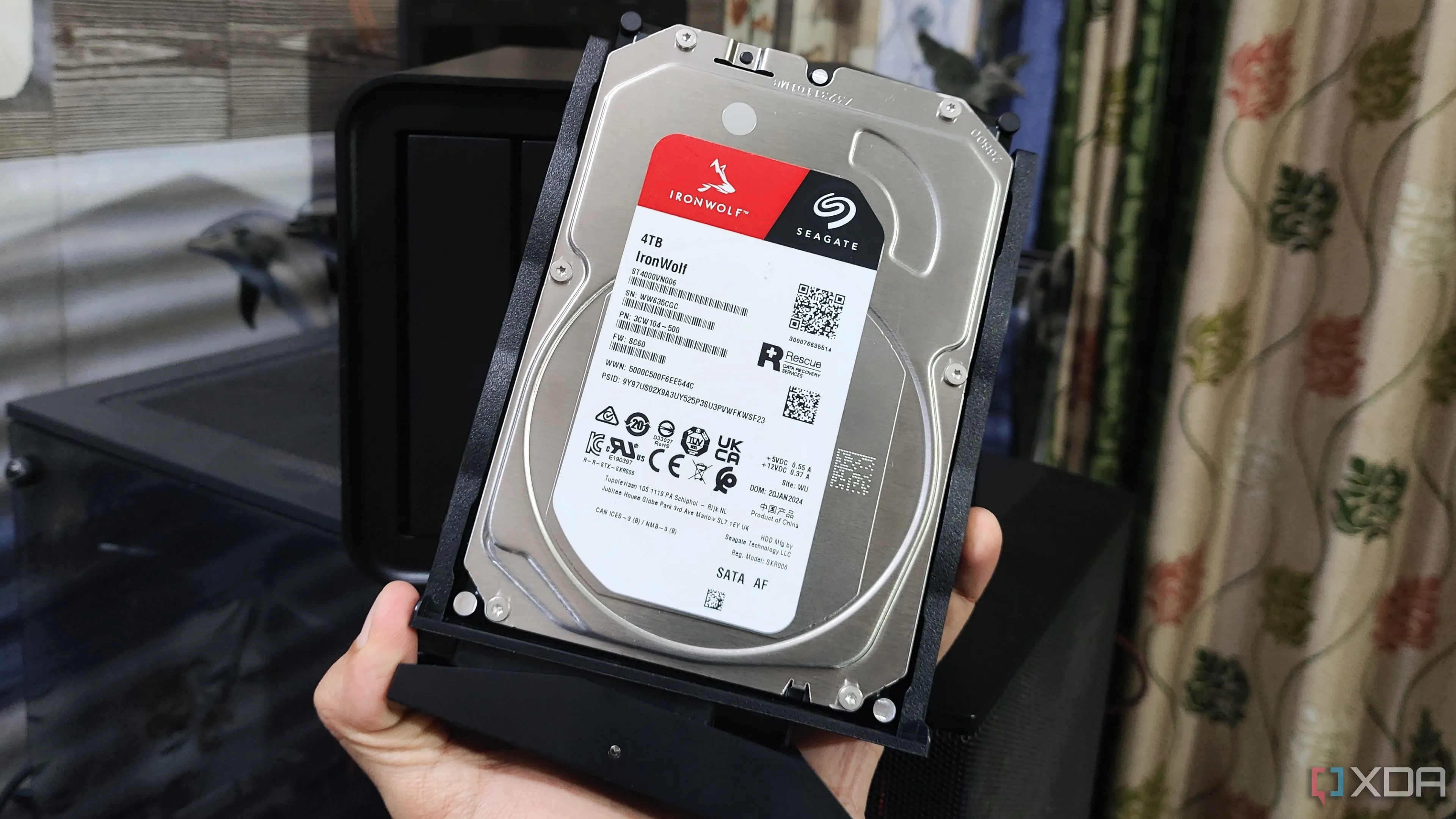 Một người đang cầm một ổ cứng HDD Seagate, thể hiện kích thước và hình dạng của thiết bị lưu trữ