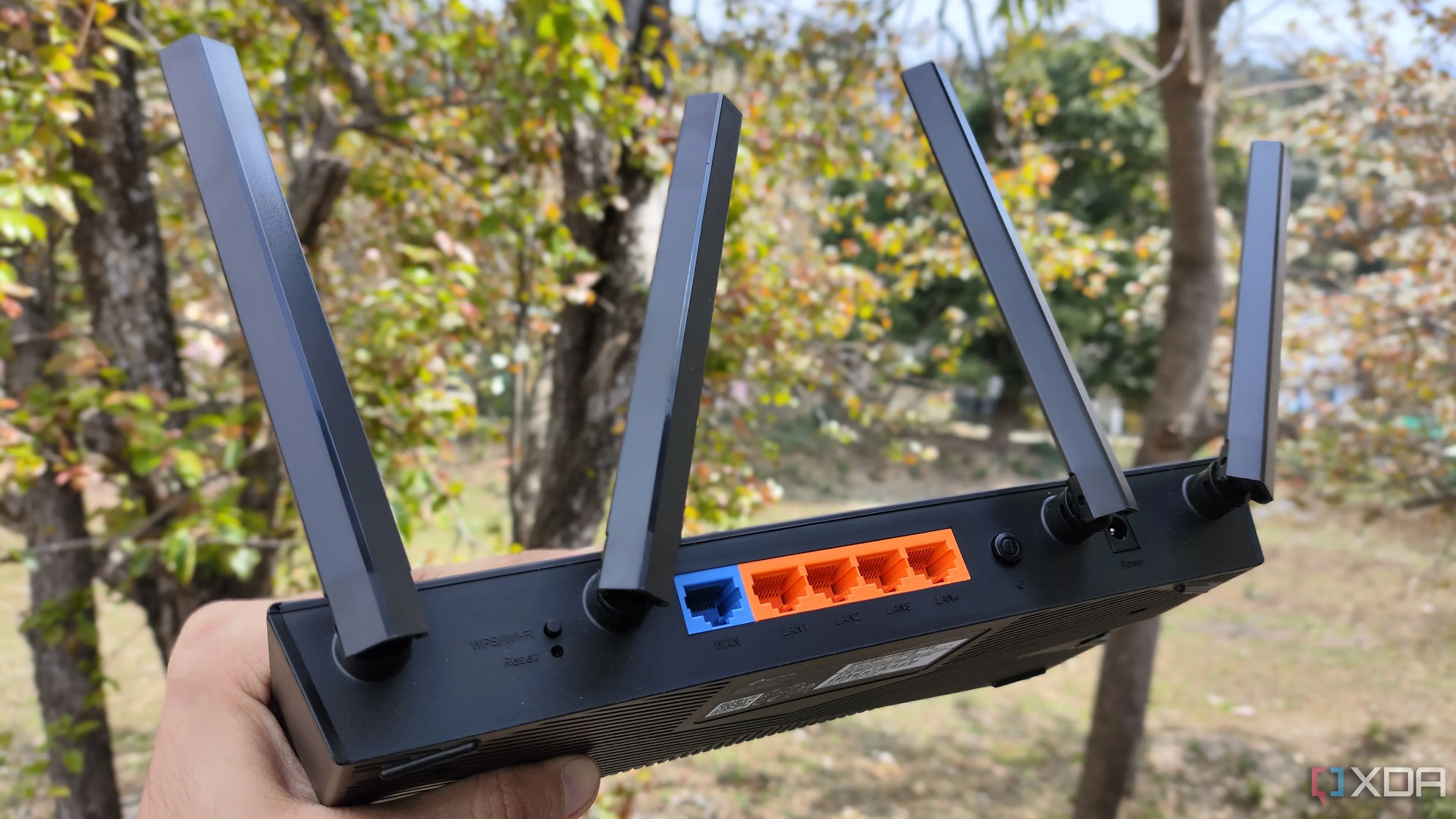 Một người đang cầm router TP-Link với nhiều cổng Ethernet, minh họa sự cần thiết của đủ cổng kết nối cho hệ thống mạng