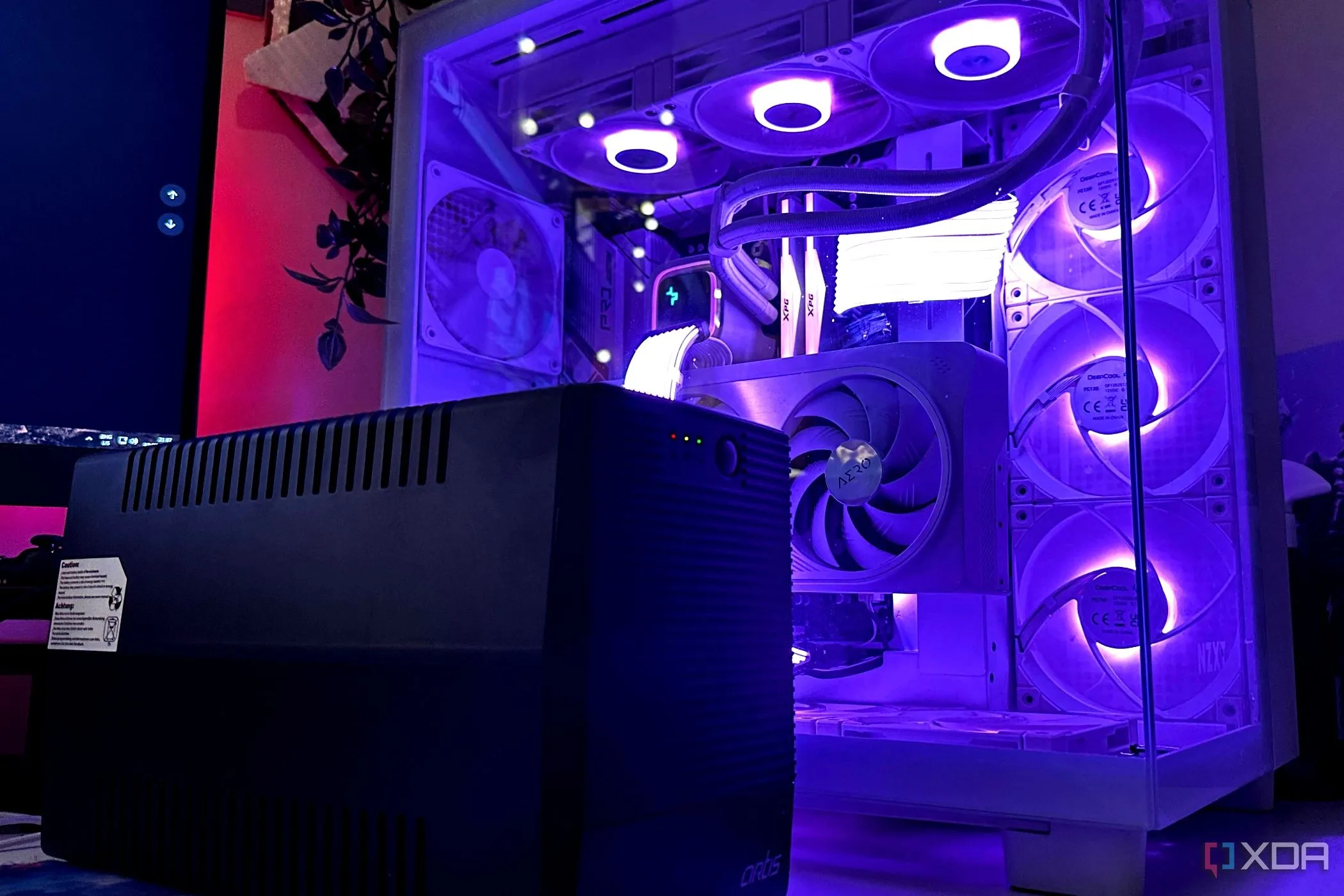 Một UPS màu đen đặt cạnh thùng máy tính gaming