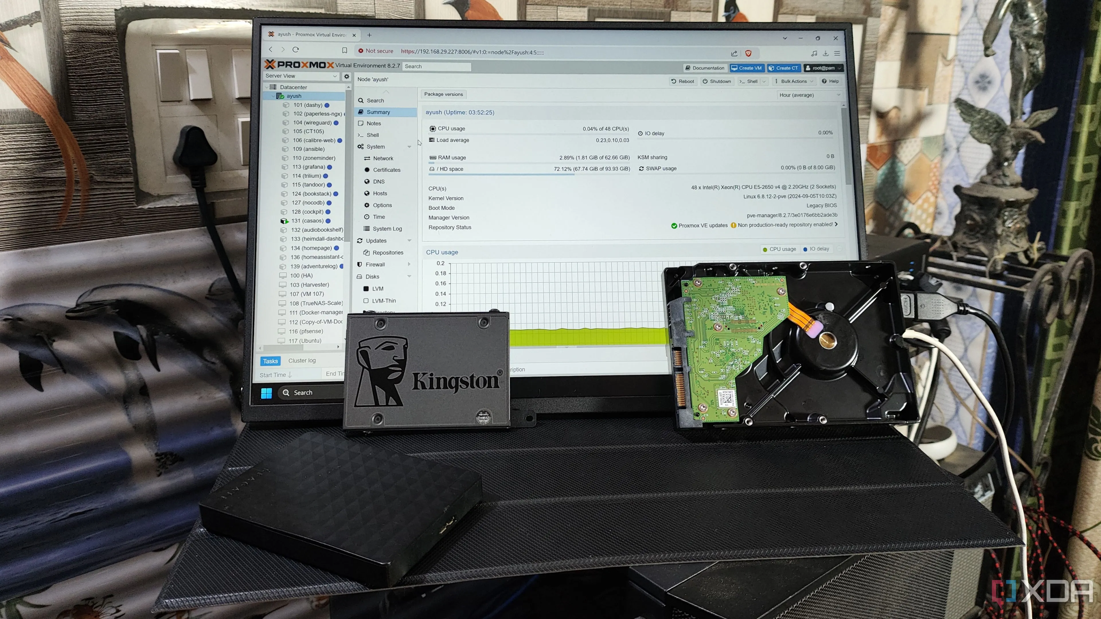 Một vài ổ HDD và một SSD Kingston đặt trước màn hình hiển thị giao diện web Proxmox