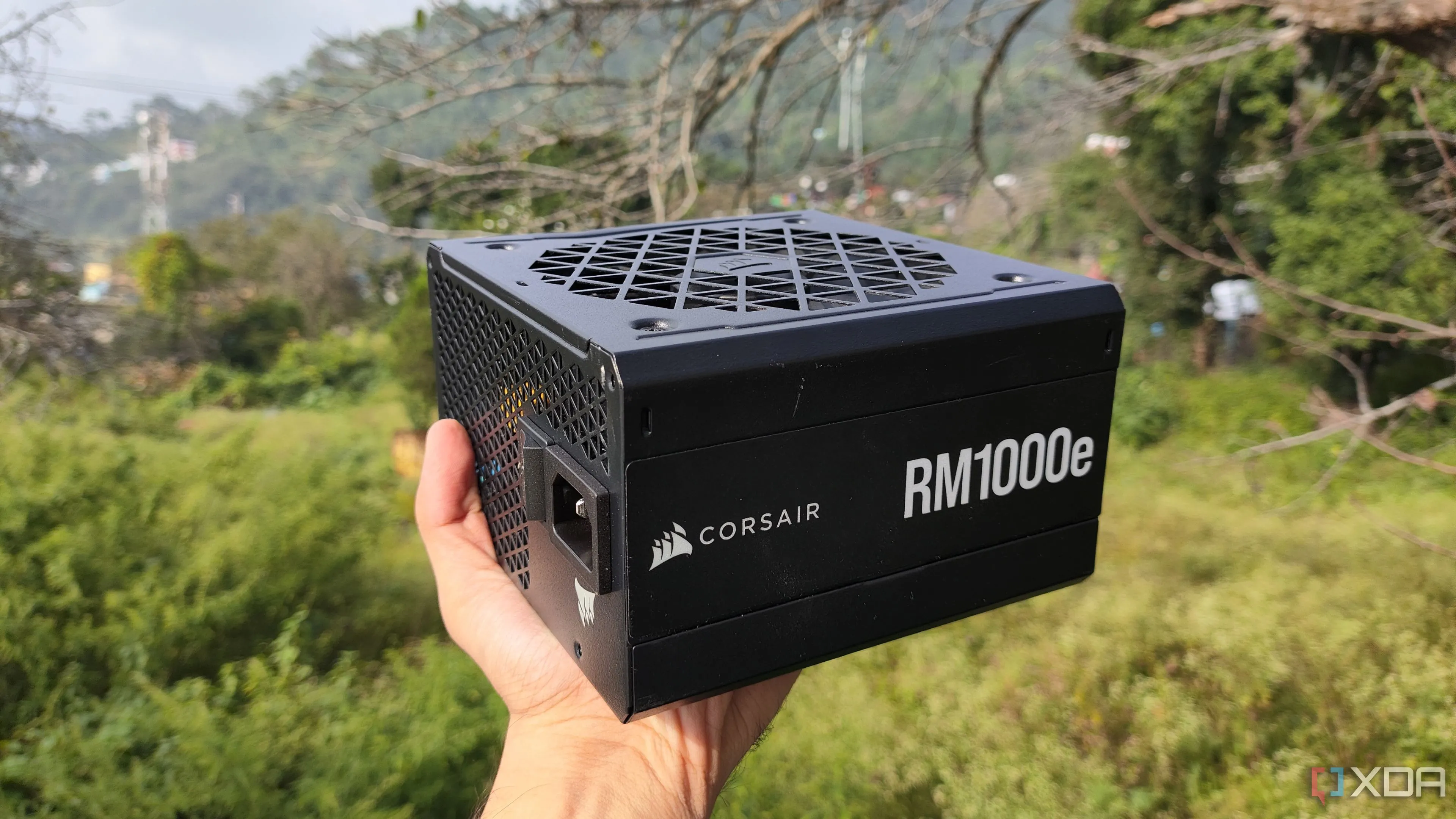 Người dùng cầm bộ nguồn Corsair RM1000e, minh họa cho yêu cầu PSU cao cấp khi nâng cấp RTX 5090