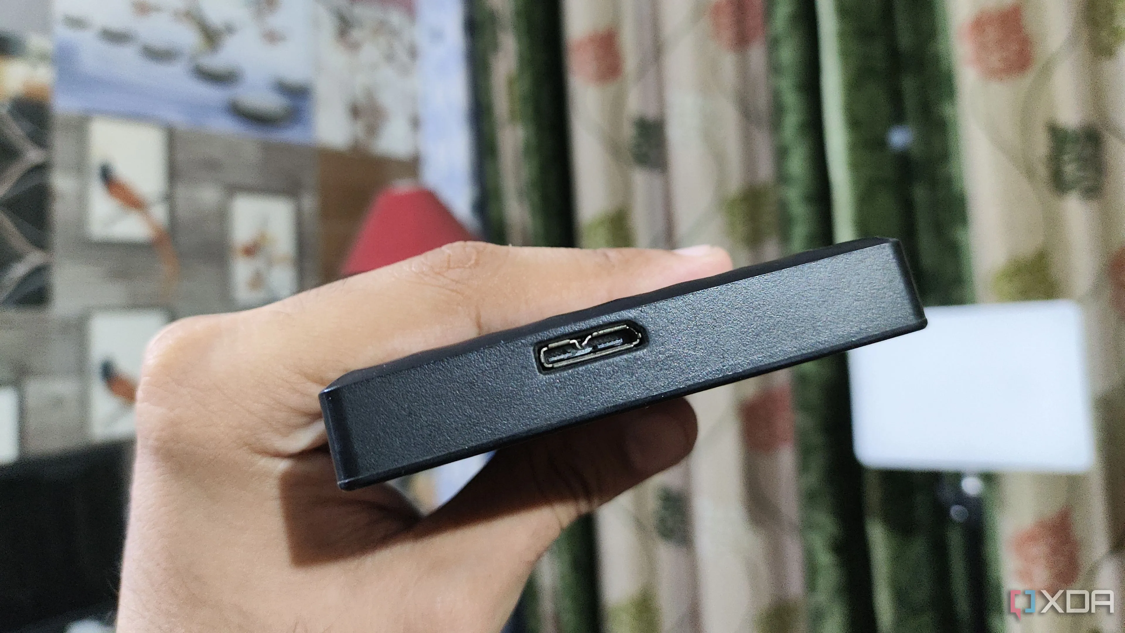 Người dùng đang cầm ổ cứng HDD gắn ngoài, nhấn mạnh nguy cơ hư hỏng khi rơi rớt