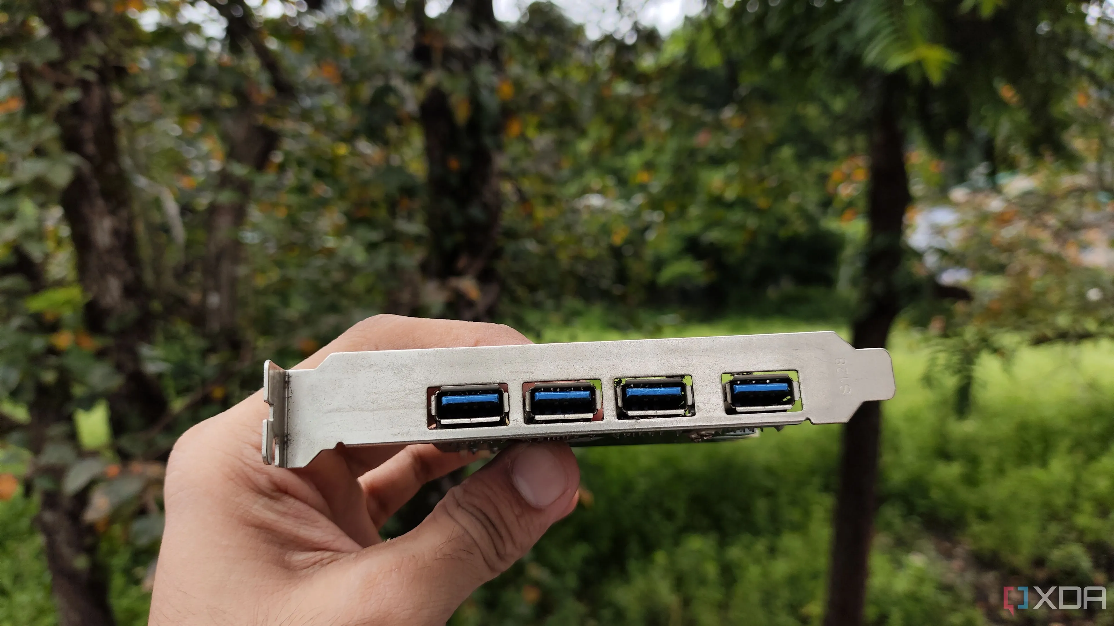 Người dùng đang cầm thẻ mở rộng USB PCIe để bổ sung cổng kết nối cho PC