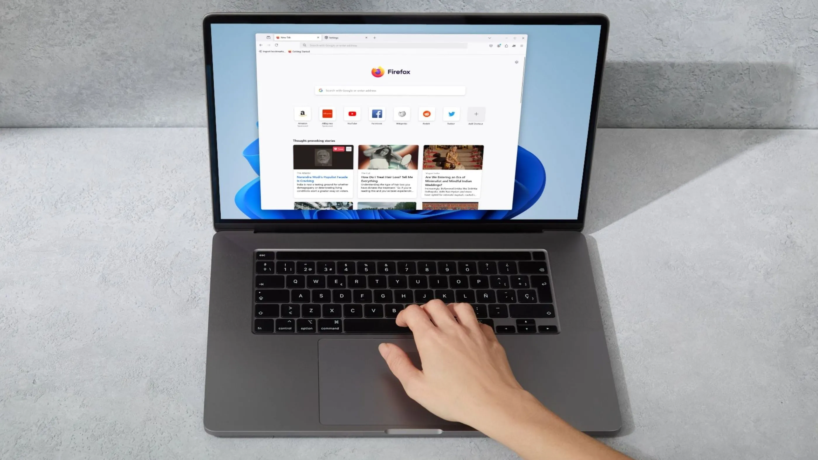 Người dùng đang gõ trên laptop, màn hình hiển thị trình duyệt Firefox
