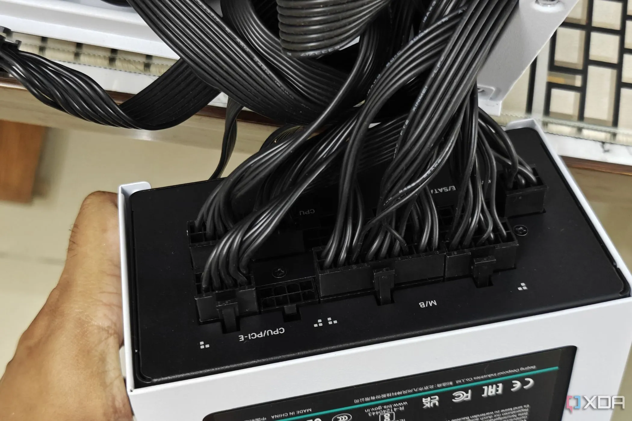 Nguồn máy tính (PSU) với nhiều dây cáp nguồn được kết nối, minh họa tầm quan trọng của việc chọn PSU chất lượng