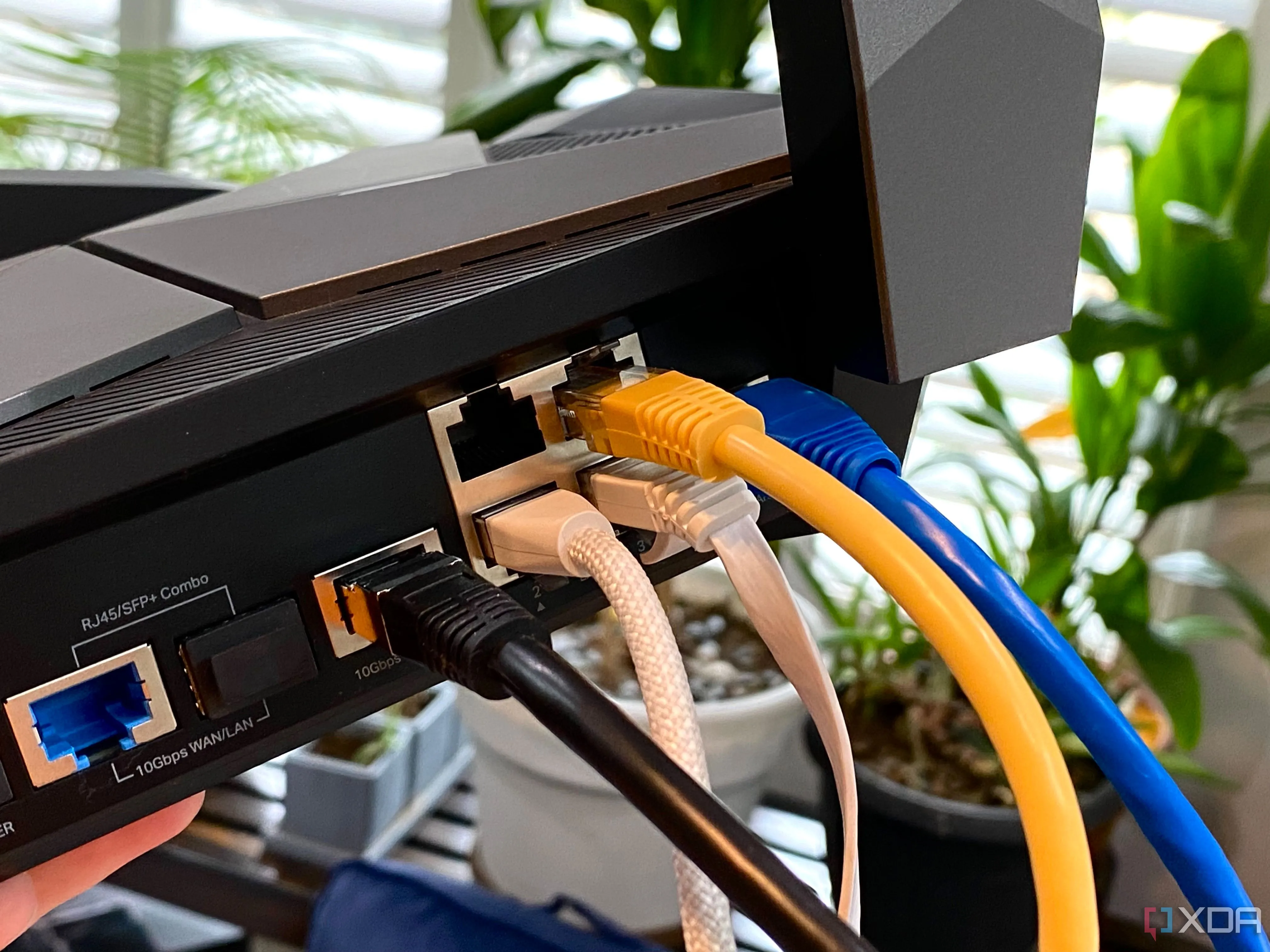 Nhiều loại cáp Ethernet nhiều màu sắc được cắm vào router TP-Link Archer AXE300