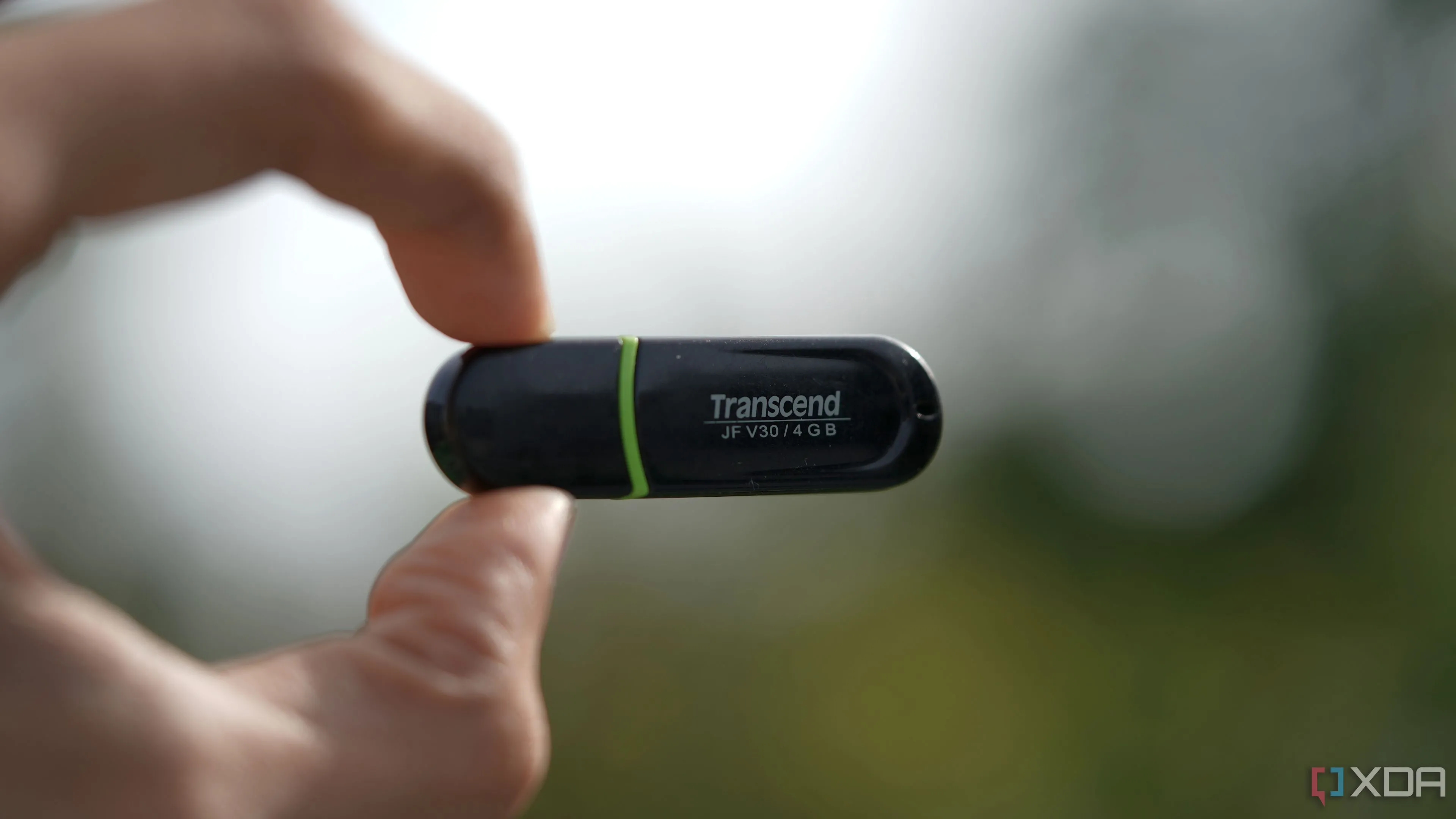 Ổ USB Transcend 4GB nhỏ gọn trong tay, tượng trưng cho những thiết bị lưu trữ cũ kỹ, dung lượng thấp