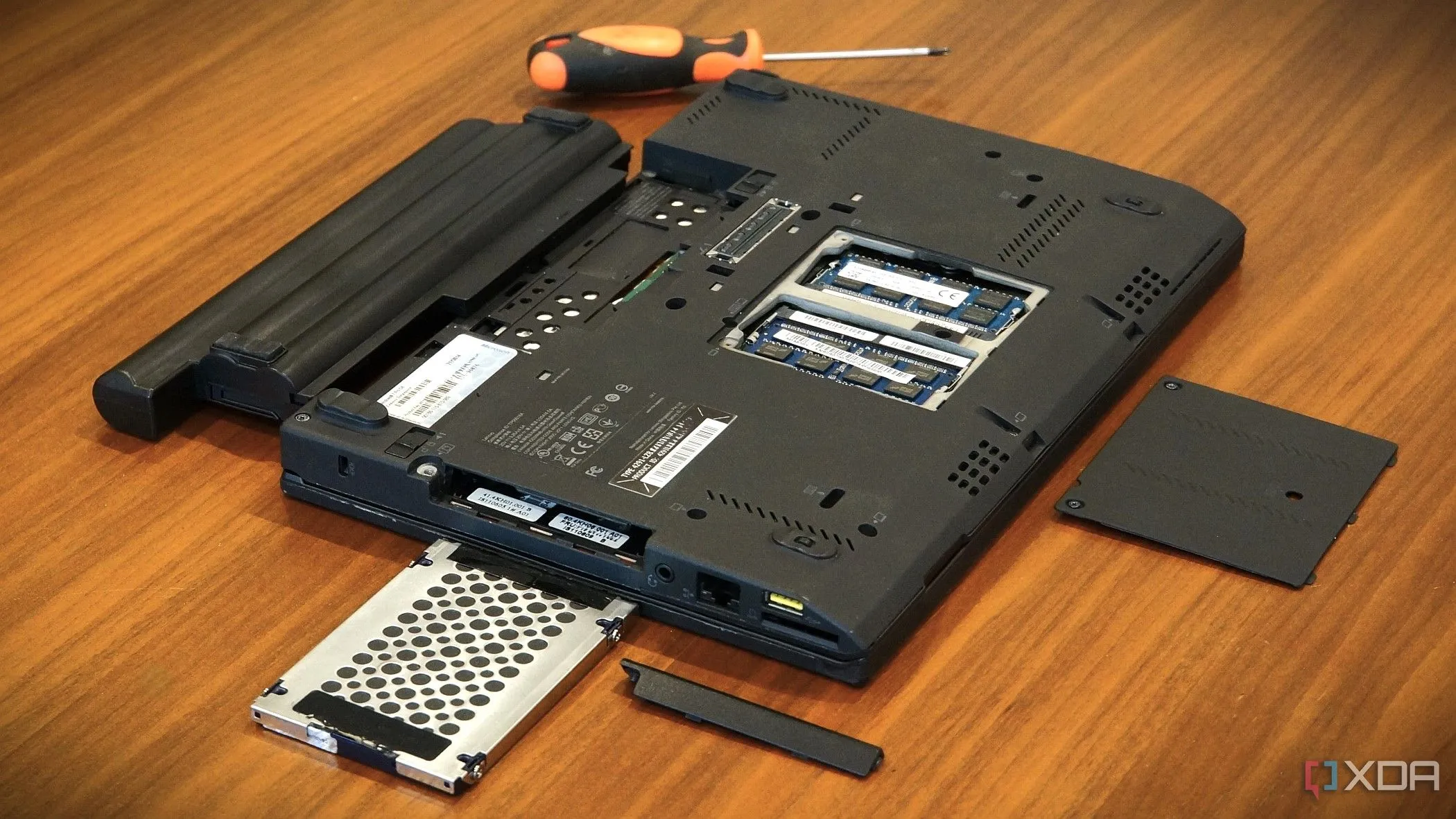 Pin laptop Lenovo x220 đã tháo rời, cho thấy các khe cắm và khoang mở rộng