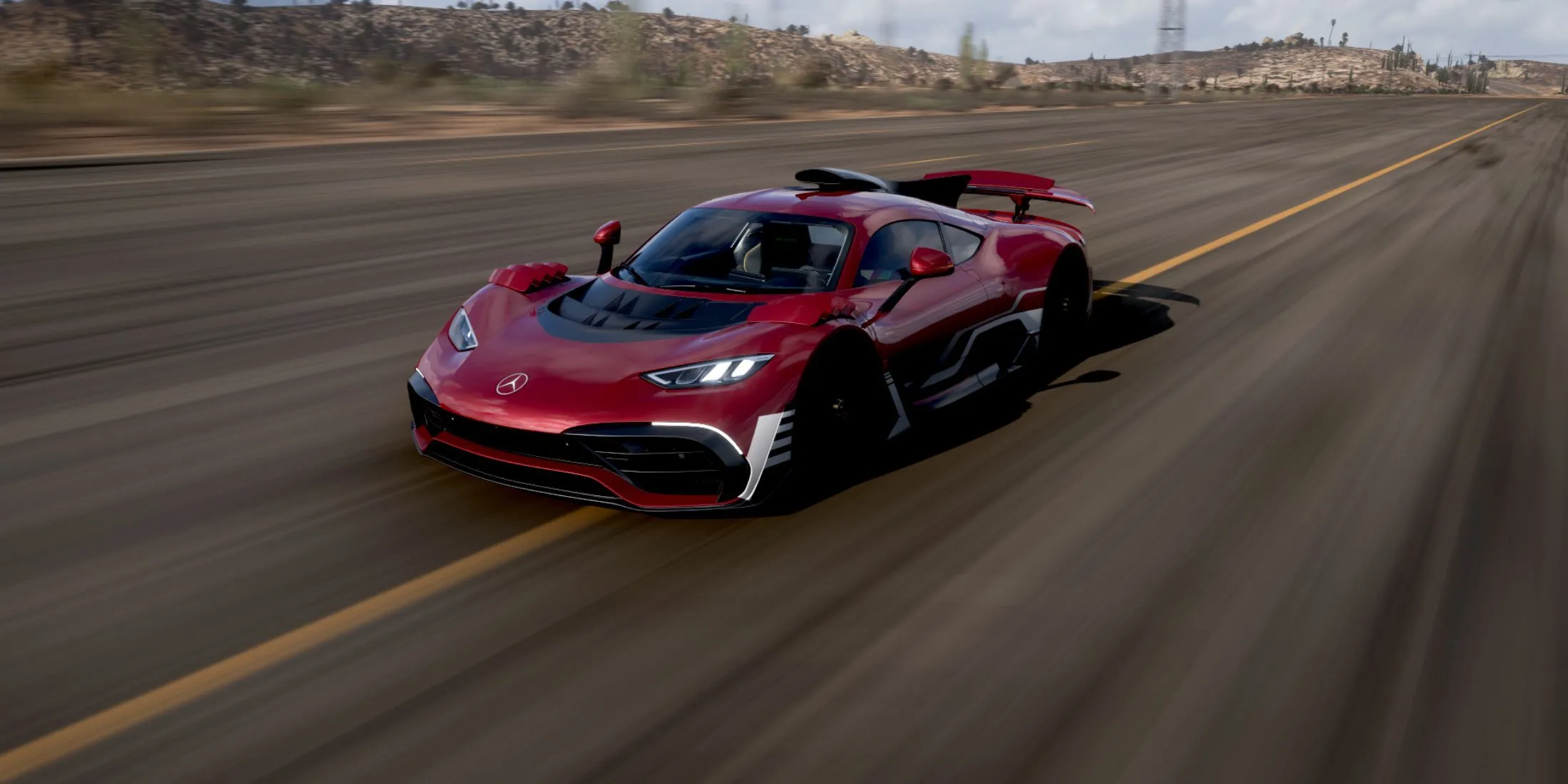 Siêu xe Mercedes-AMG One màu đỏ đang tăng tốc trên đường đua trong Forza Horizon 5 dưới trời nắng vàng