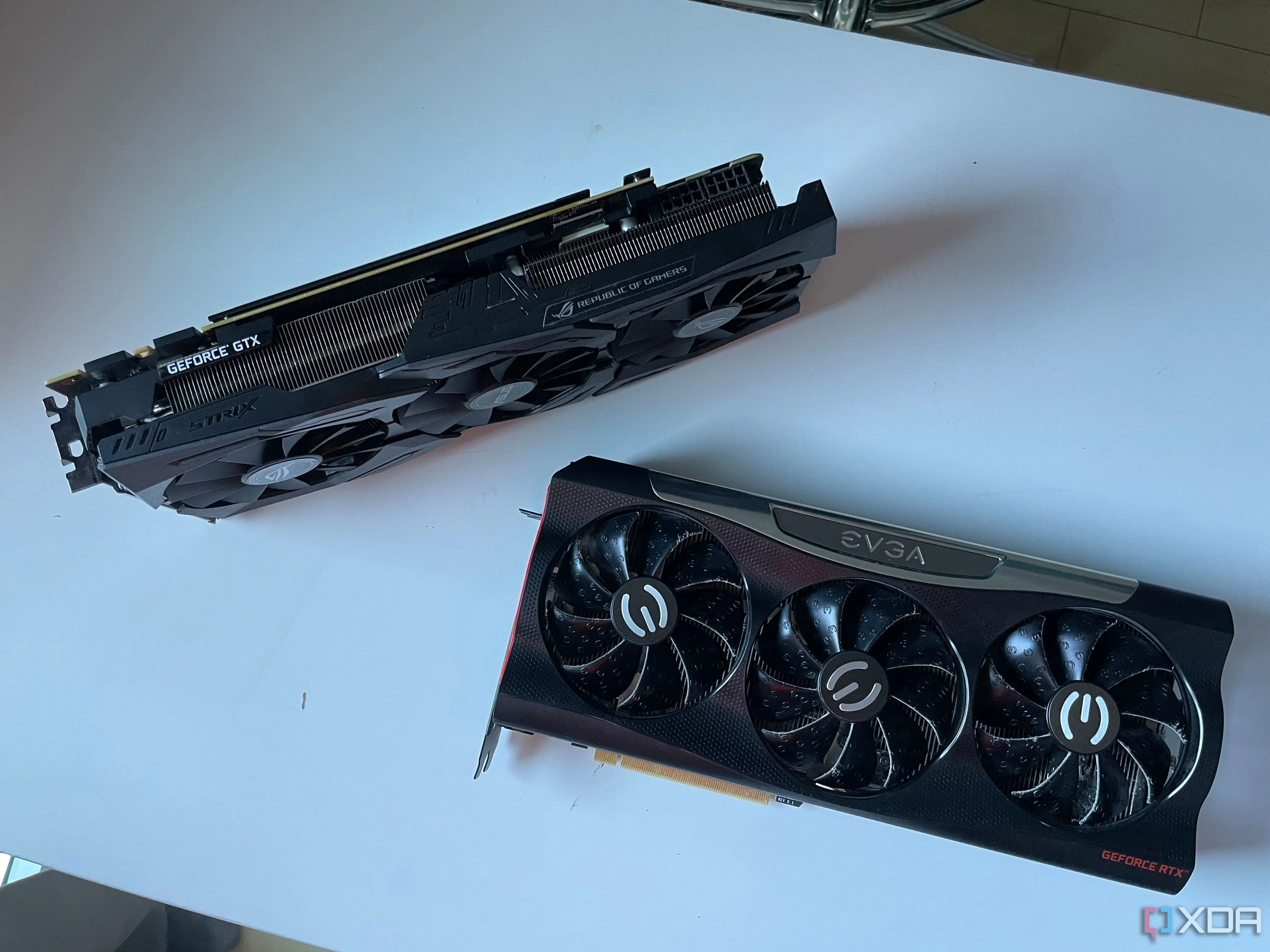So sánh card đồ họa ASUS STRIX GTX 1080 Ti và EVGA RTX 3080 trên bàn, minh họa sự thay đổi hiệu năng qua các thế hệ GPU