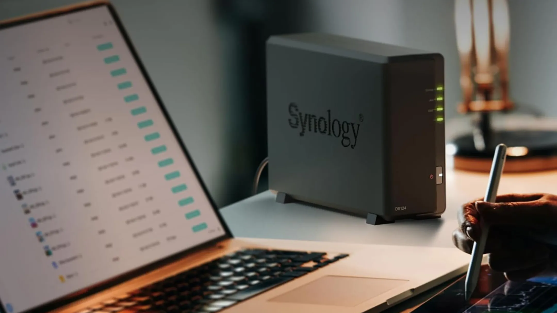 Synology DS124 đặt trên bàn làm việc cạnh laptop, minh họa khả năng truy cập tiện lợi