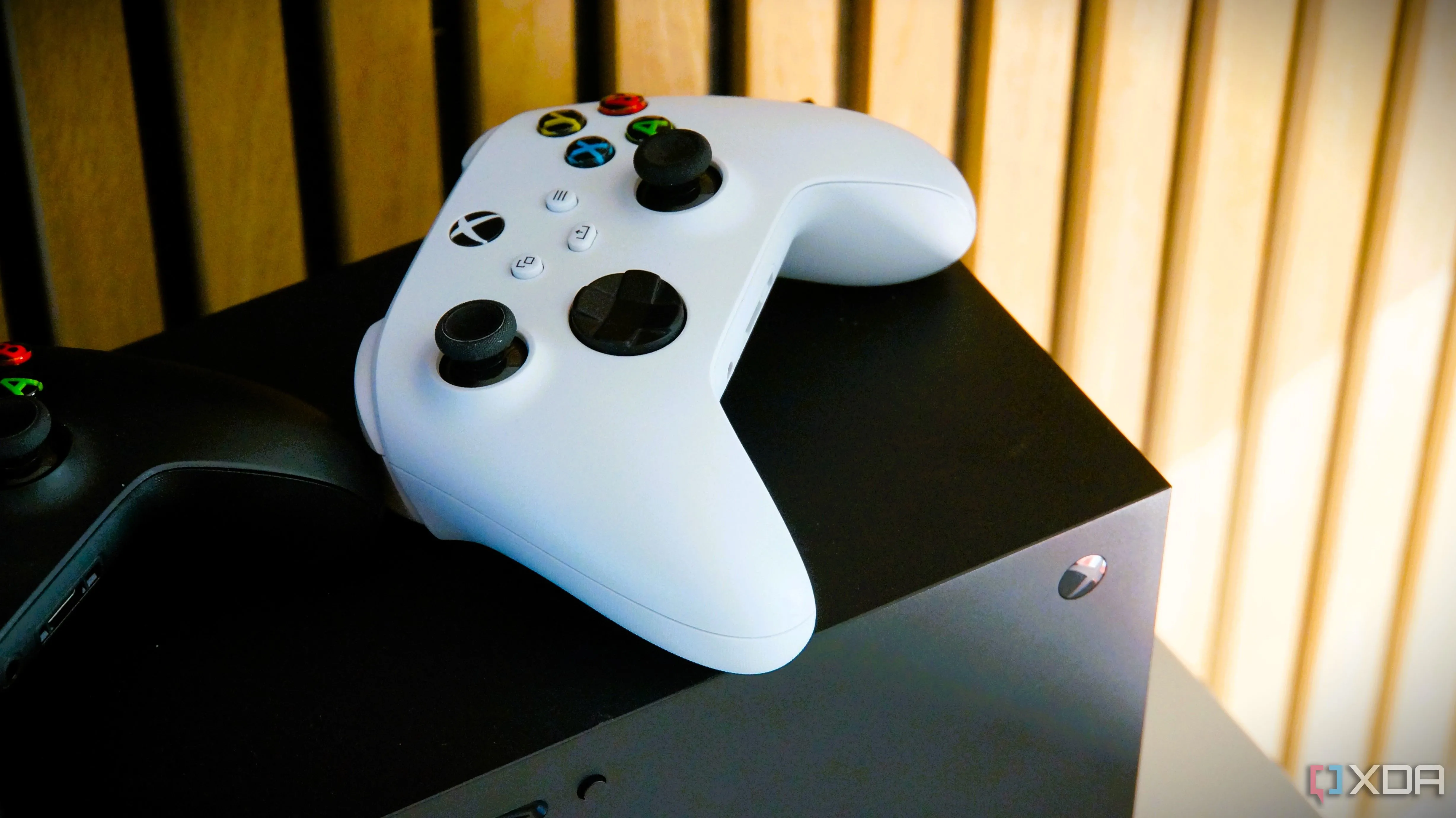 Tay cầm Xbox màu trắng đặt trên console Xbox Series X, minh họa sự hấp dẫn của các hệ máy chơi game console