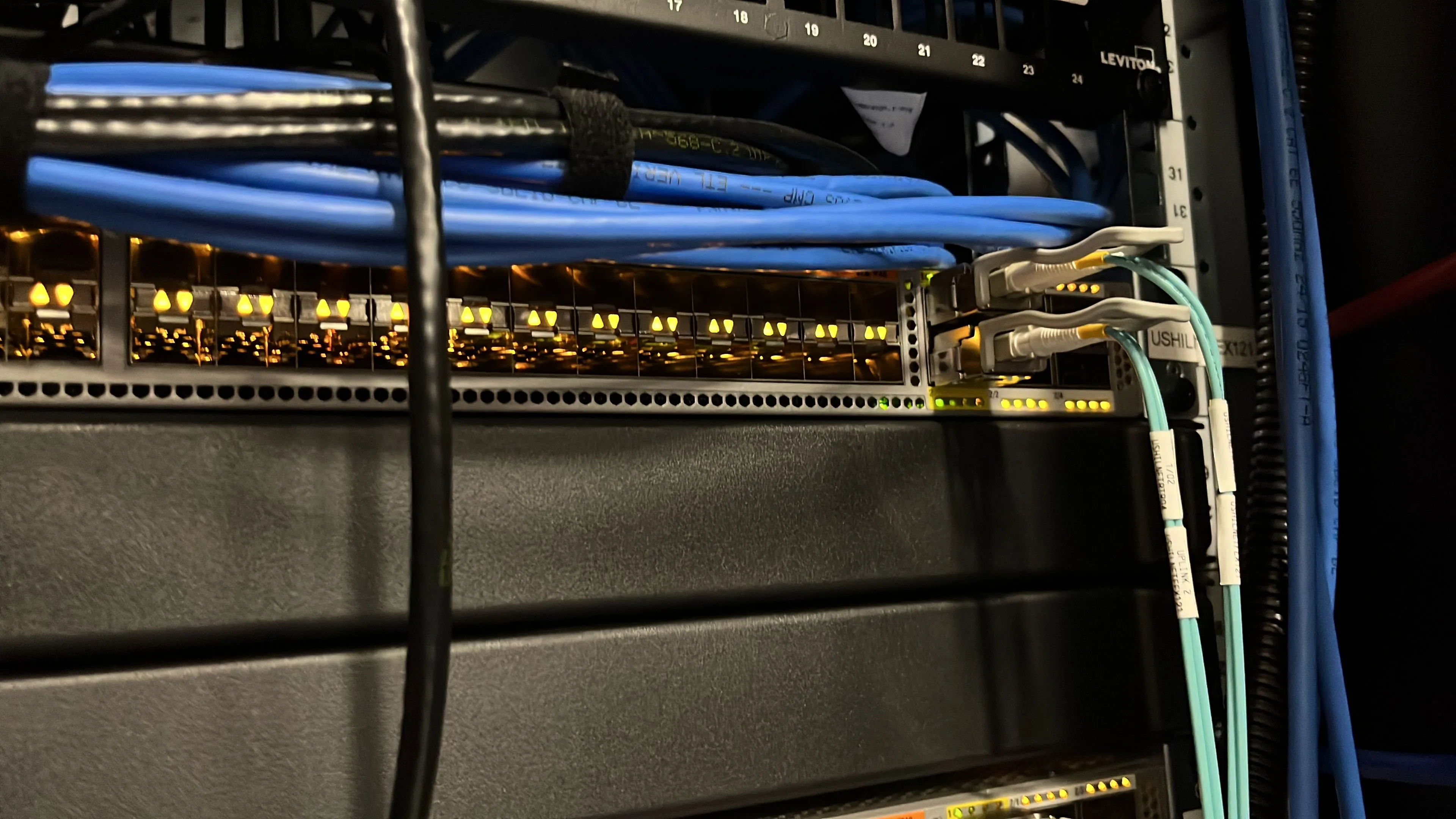 Thiết bị chuyển mạch mạng (network switch) với hệ thống dây cáp được quản lý gọn gàng, tượng trưng cho một hạ tầng mạng gia đình (home lab) được tổ chức tốt