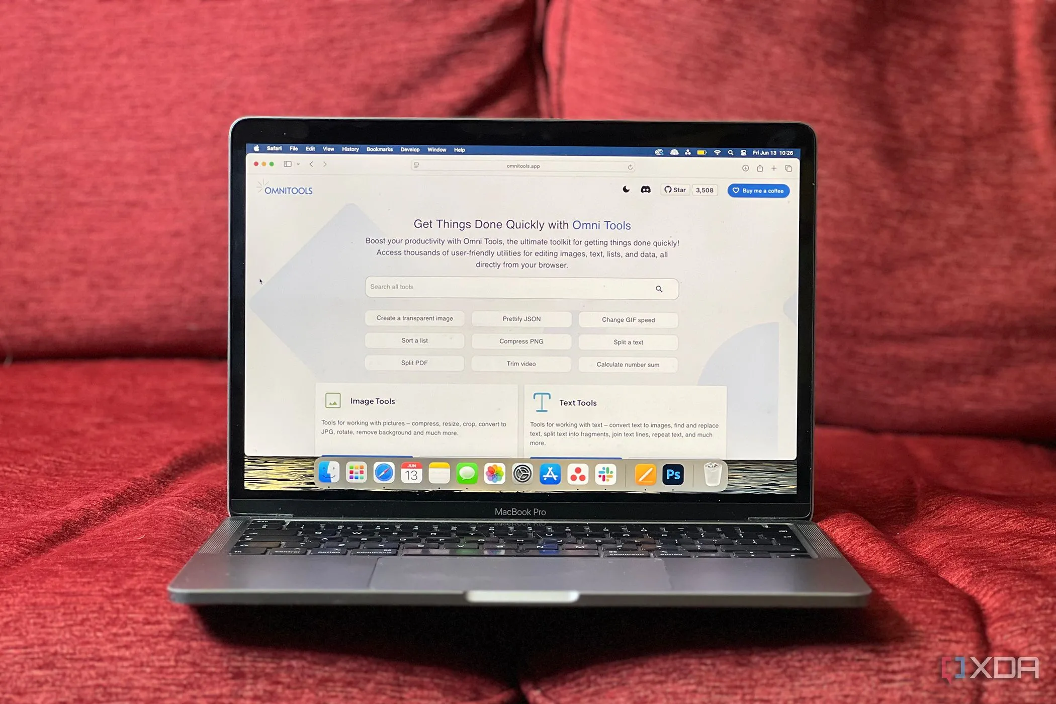 Trang chủ Omni Tools hiển thị trên MacBook Pro đặt trên ghế sofa đỏ, một ví dụ về công cụ thiết kế sáng tạo